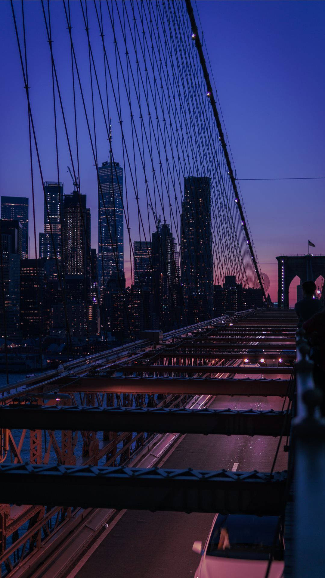 New York 桌布 壁紙 — 黃昏時分的布魯克林大橋，城市燈光在紫色天空下閃耀。