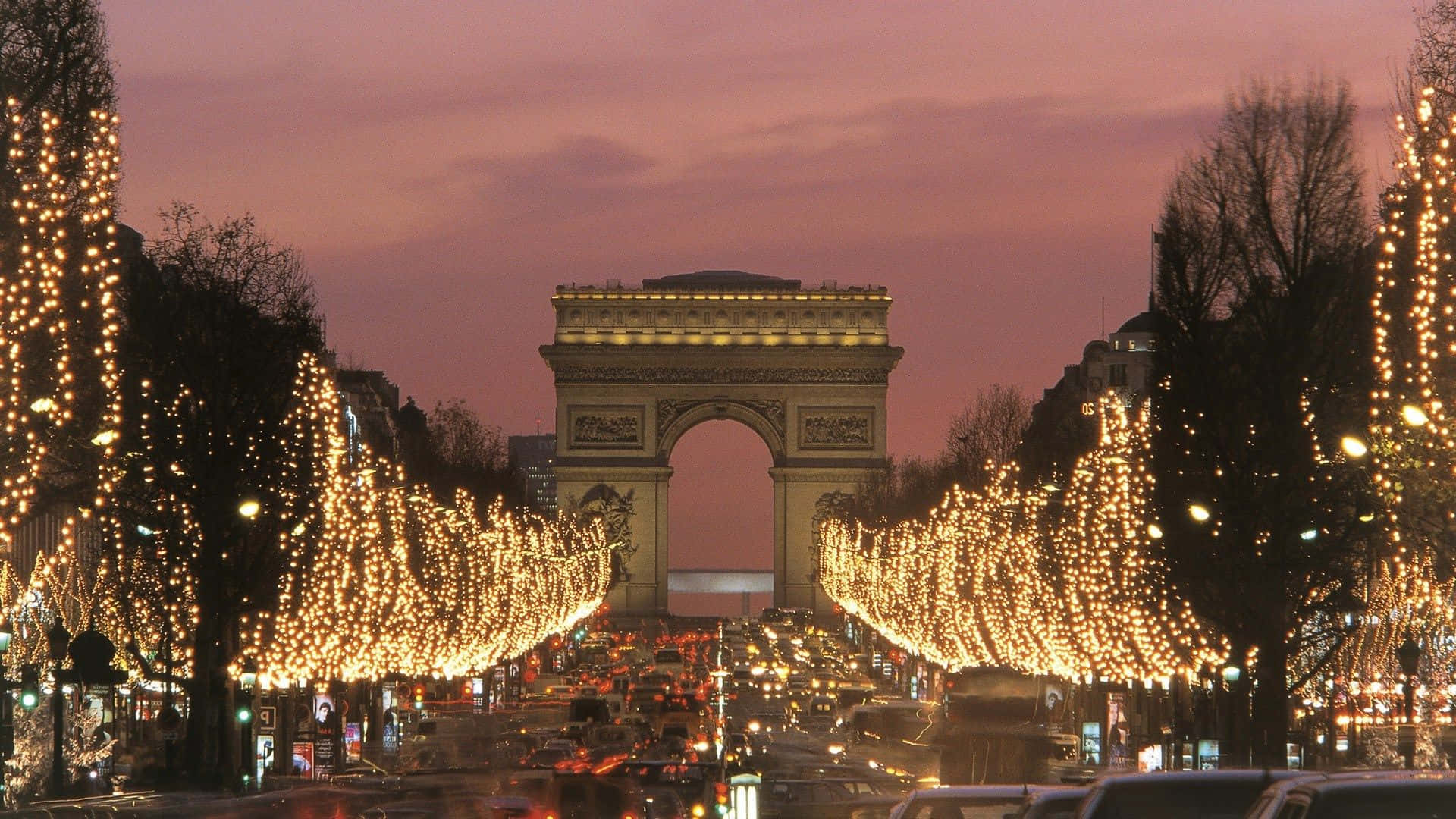 Paris Desktop 桌布 壁紙 — 黃昏時分的戰神廣場大道，凱旋門被光禿樹木上的節日燈串照亮。