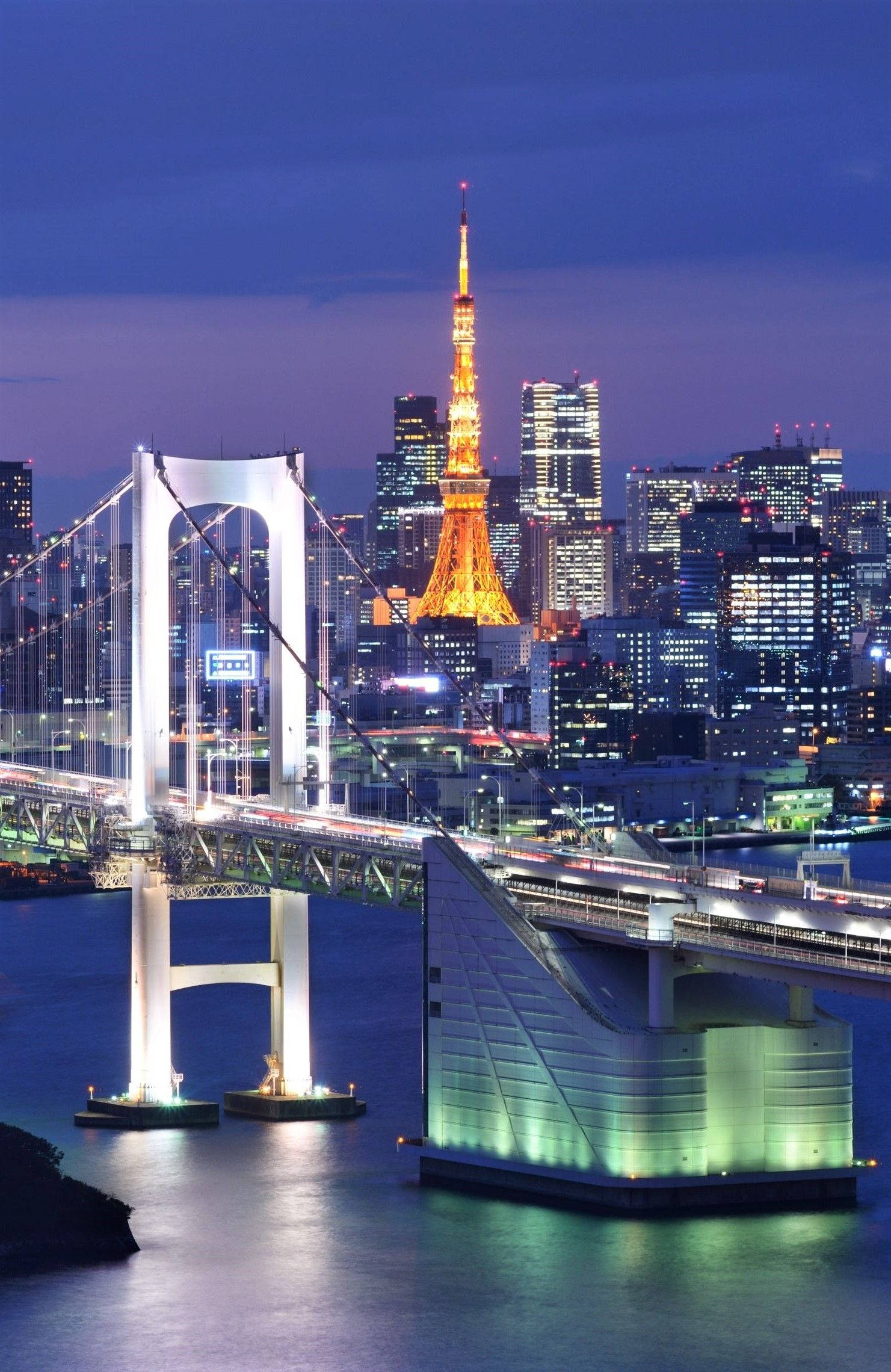日本 桌布 壁紙 — 黃昏時分的東京天際線，彩虹橋和東京塔在平靜的水面上倒映著燈光。