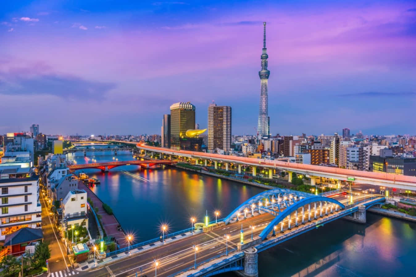東京 桌布 壁紙 — 黃昏時分的東京天際線，閃爍的橋樑和聳立於隅田川上的東京晴空塔。