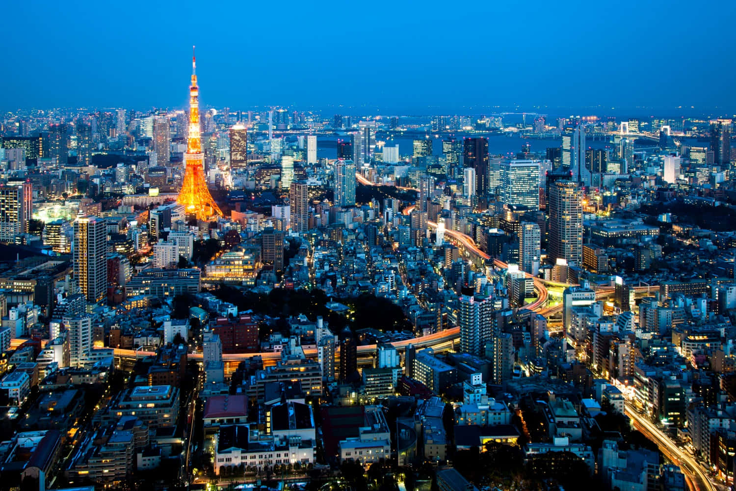 東京 桌布 壁紙 — 黃昏時分的東京天際線，閃耀的東京塔和城市燈光照亮了都市的廣闊景象。
