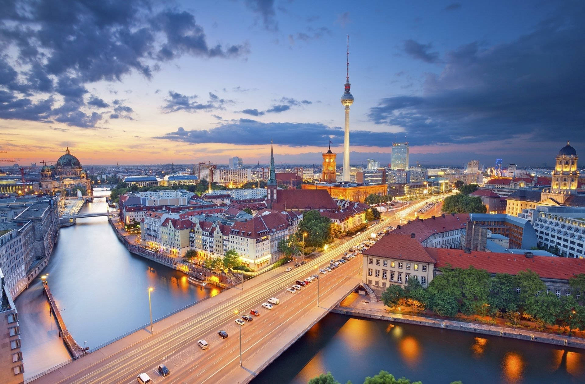 Berlin 桌布 壁紙 — 黃昏時分的柏林天際線，燈火通明的電視塔、河橋和歷史建築倒映在水中。