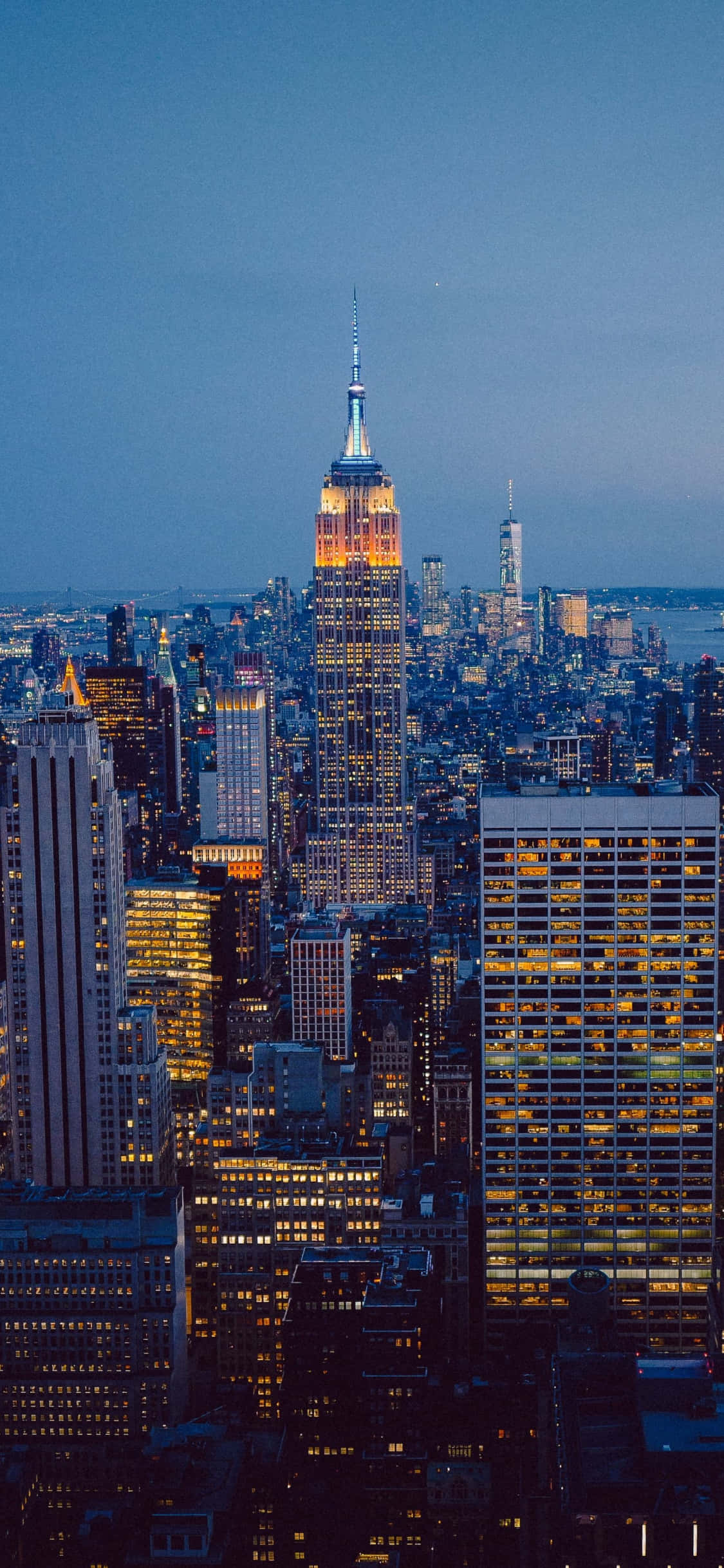 New York 桌布 壁紙 — 黃昏時分紐約市天際線的鳥瞰圖，帝國大廈在深藍色天空中閃耀。