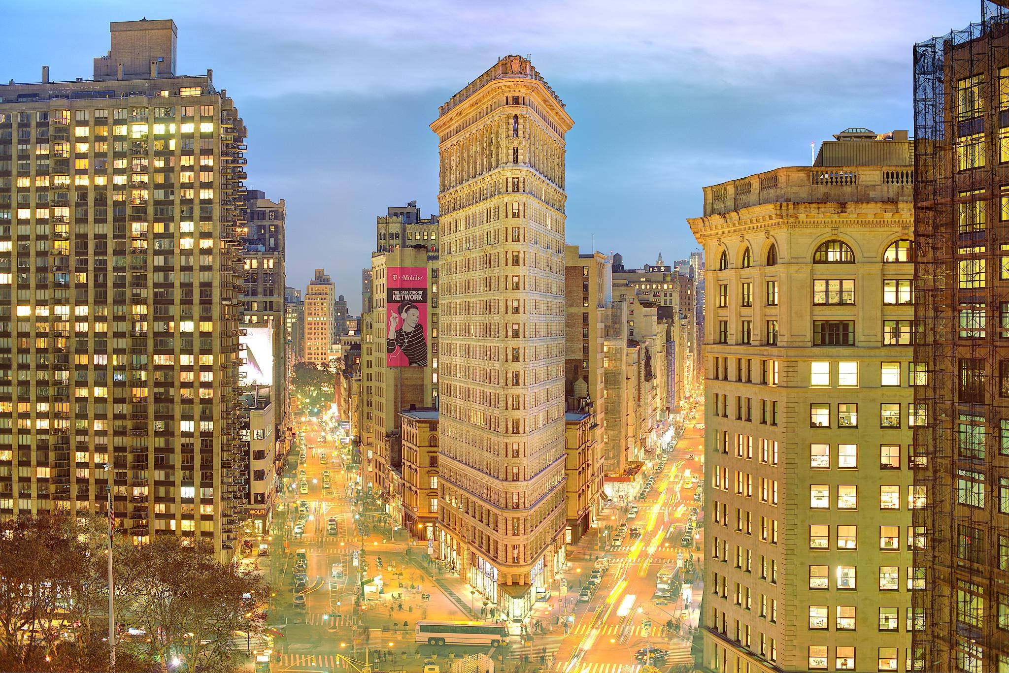 Flatiron Building 桌布 壁紙 — 黃昏時分紐約市的鳥瞰圖，熨斗大廈燈火通明，街道因交通燈而閃爍發光。