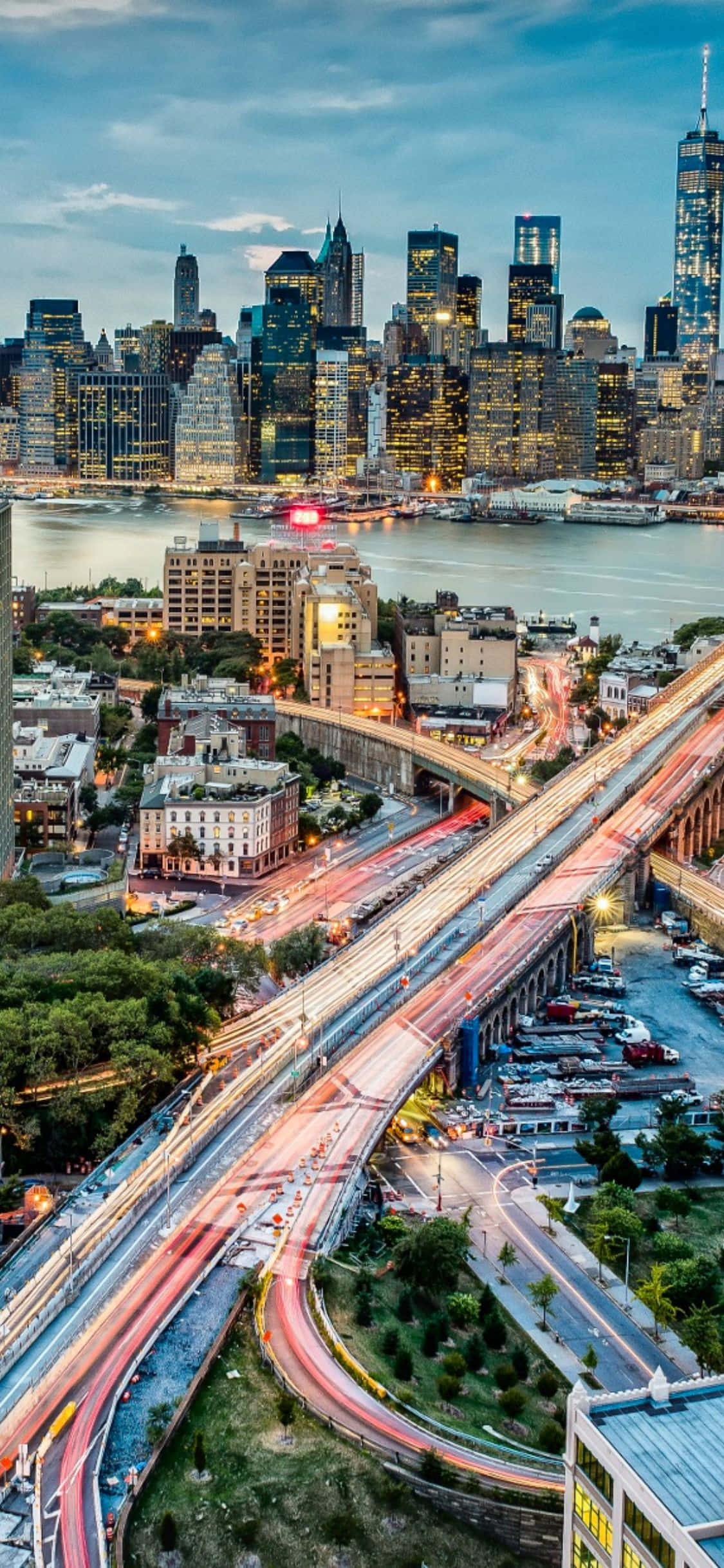 iPhone X New York 桌布 壁紙 — 黃昏時分紐約市的鳥瞰圖，閃爍的摩天大樓和高架高速公路上的車流光跡。