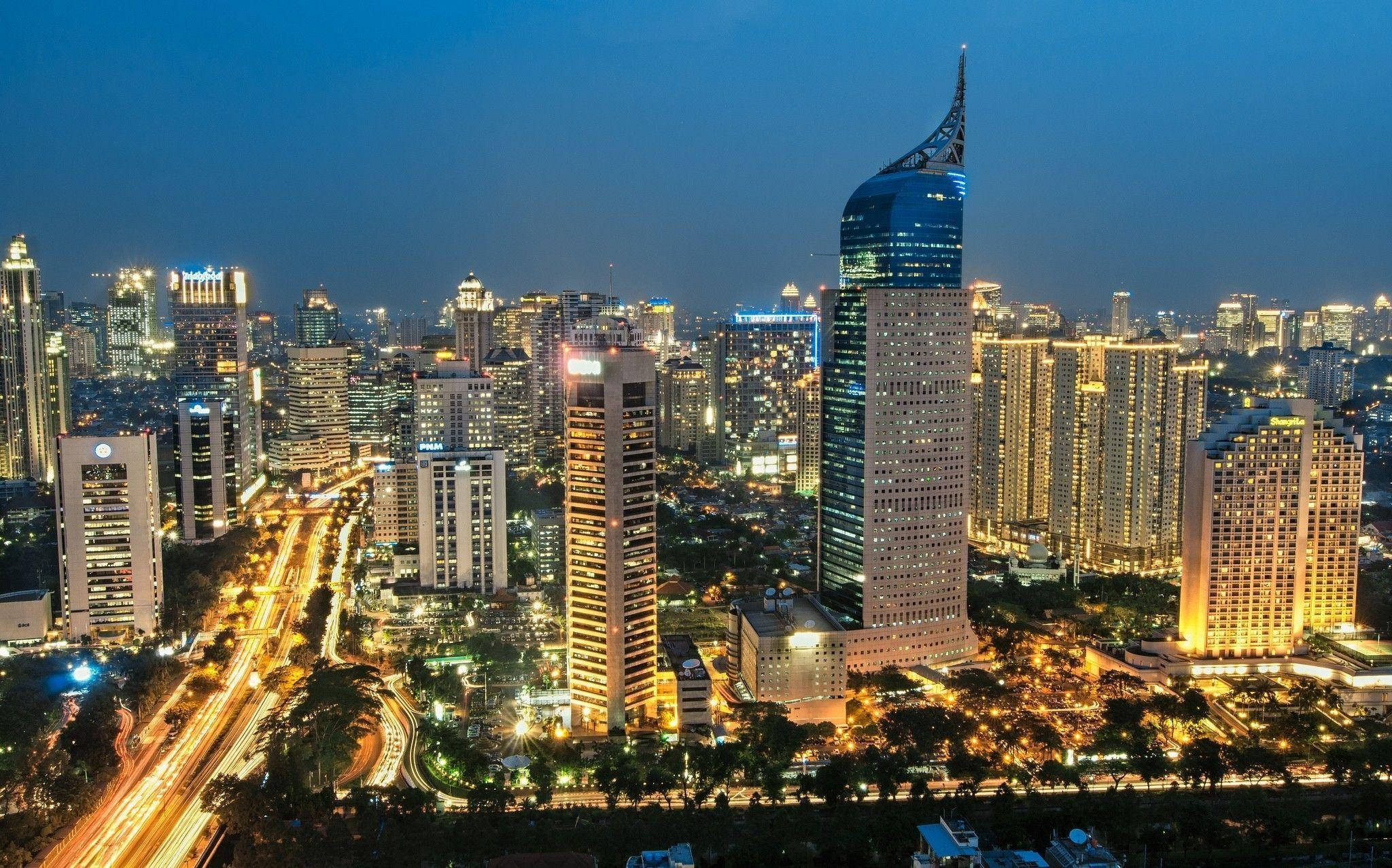 Jakarta 桌布 壁紙 — 黃昏時分繁忙城市天際線的鳥瞰圖，閃爍的摩天大樓和流動的交通燈光。
