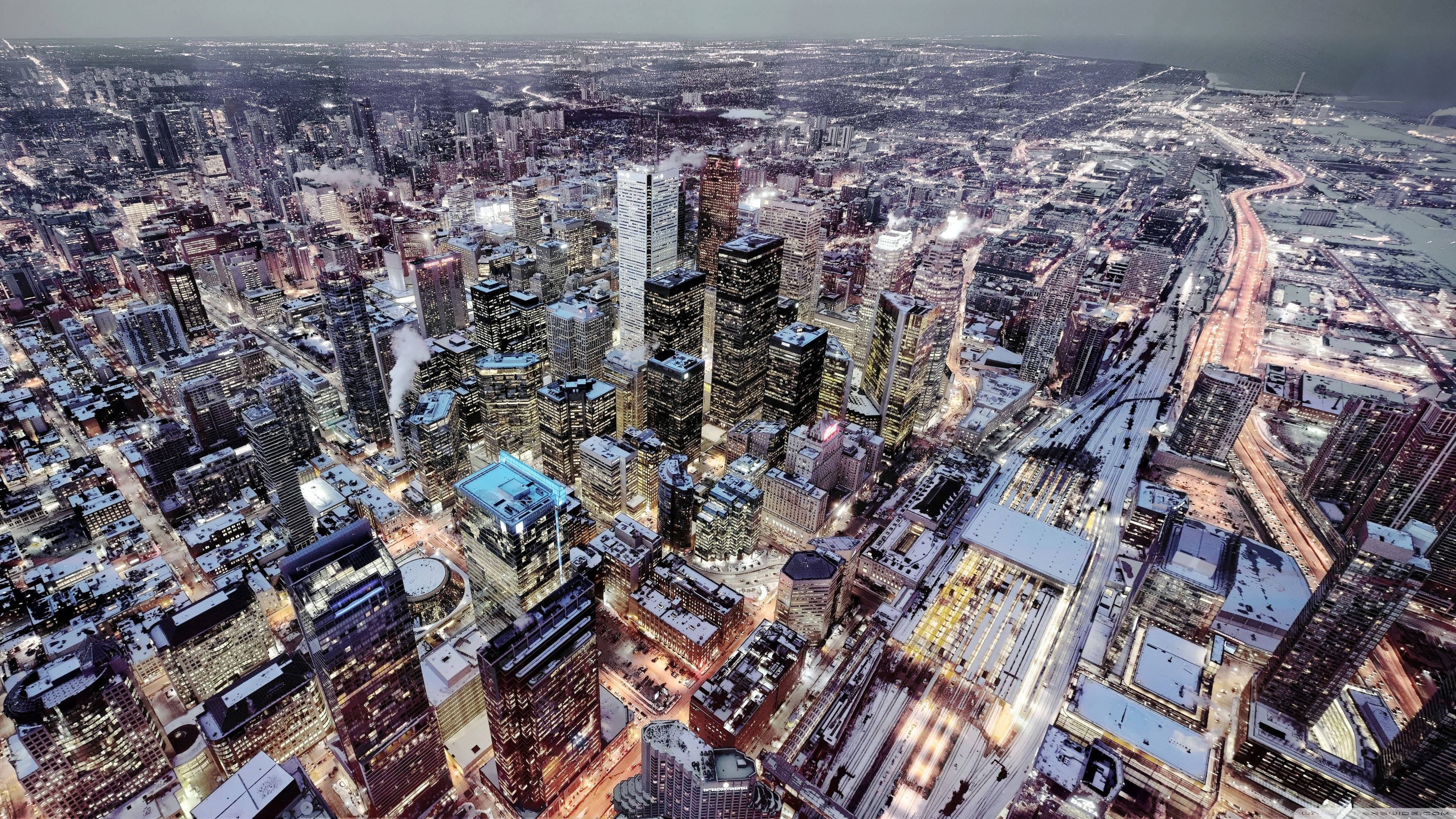 Toronto 桌布 壁紙 — 黃昏時分雪覆蓋的城市景觀鳥瞰圖，有燈火通明的摩天大樓和發光的街道。
