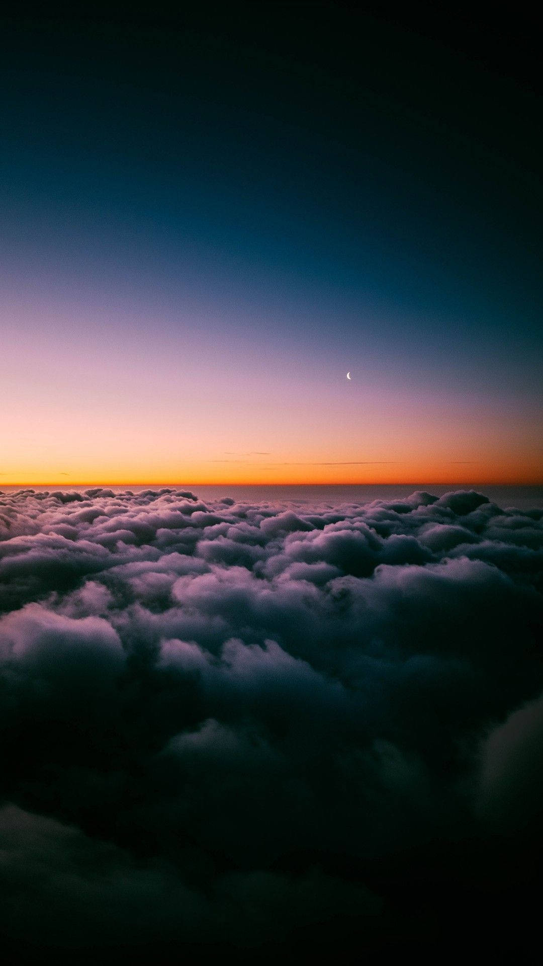Aesthetic Sky 桌布 壁紙 — 黃昏時分雲層的壯麗航拍，一彎新月在地平線上方閃耀。