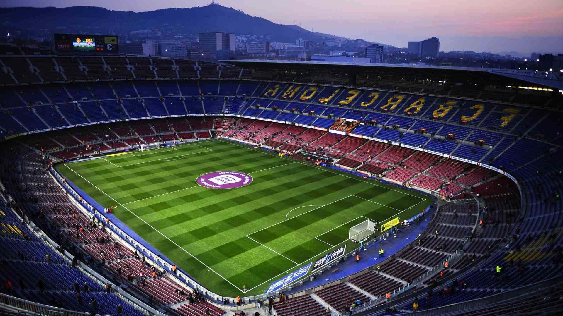 Barcelona 桌布 壁紙 — 黃昏時分魯營球場的鳥瞰圖，空置的紅色和藍色座位圍繞著充滿活力的綠色草坪。