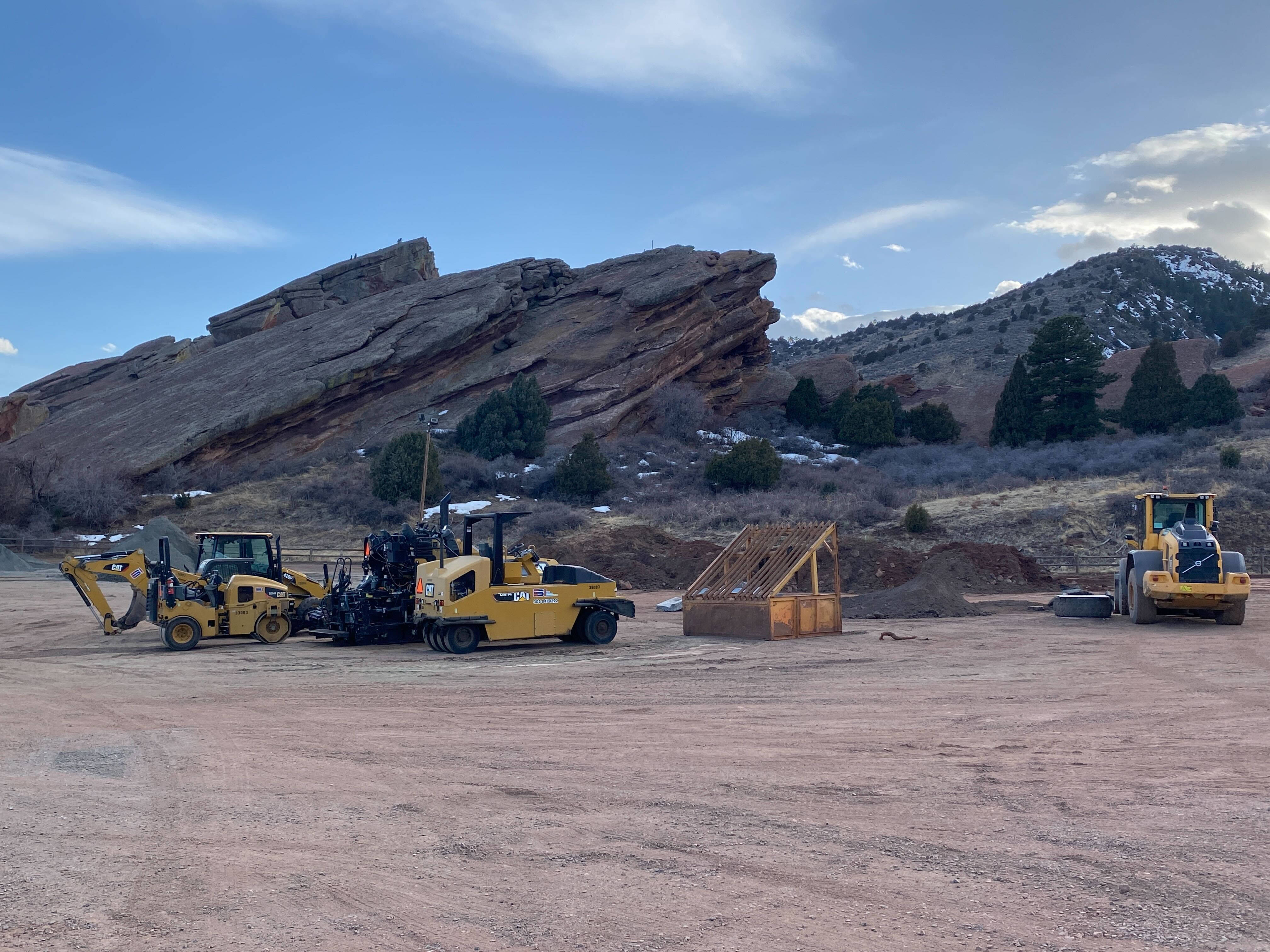 Mining 桌布 壁紙 — 黃色建築車輛在塵土飛揚的地塊上閒置，背景是廣闊的藍天和散落的雲朵，靠近崎嶇的紅色岩層。