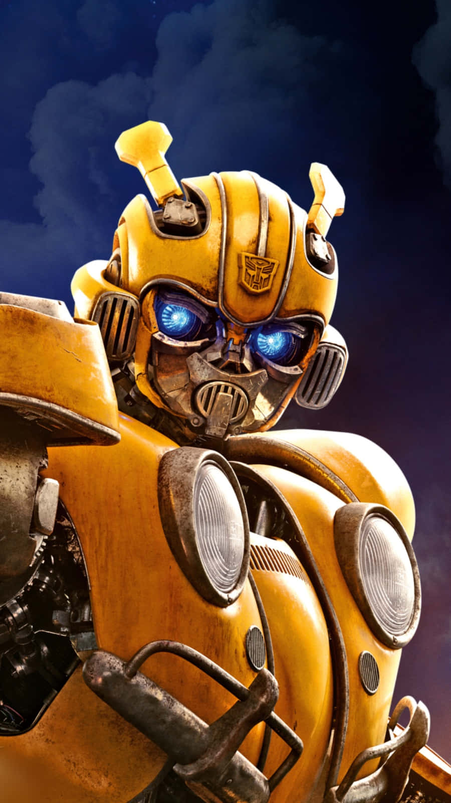 Bumblebee 桌布 壁紙 — 黃色機器人Bumblebee的特寫，藍色發光眼睛，背景是黑暗多雲的天空。