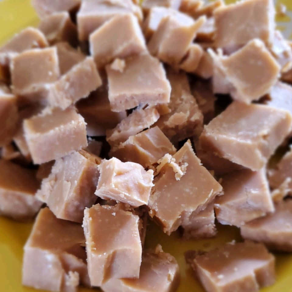 Penuche Fudge 桌布 壁紙 — 黃色盤子上的立方體軟糖塊特寫，質地平滑。