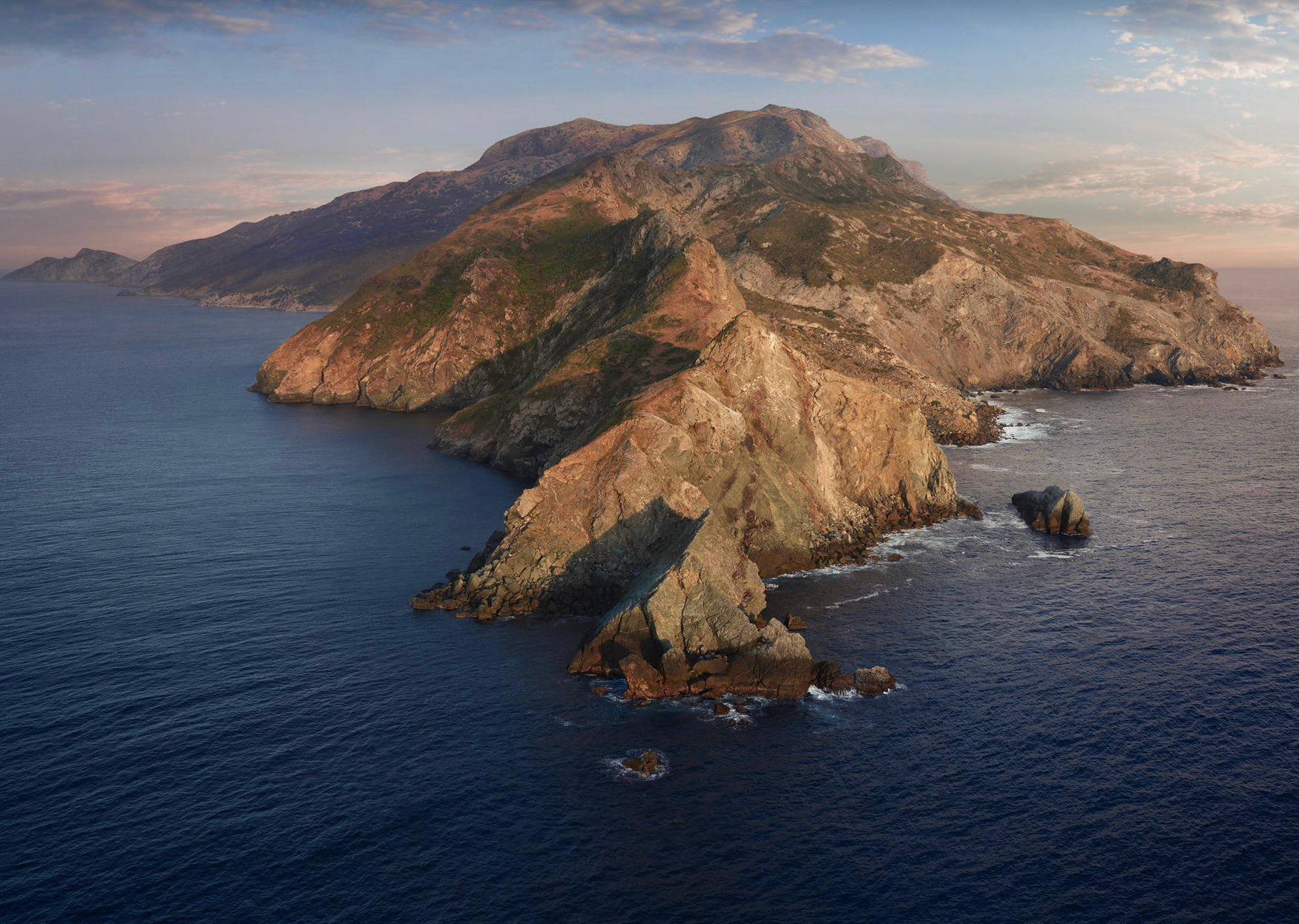Catalina 桌布 壁紙 — 黃金時分，深藍海洋環繞著崎嶇岩石島嶼，陡峭懸崖與稀疏綠意的鳥瞰圖。