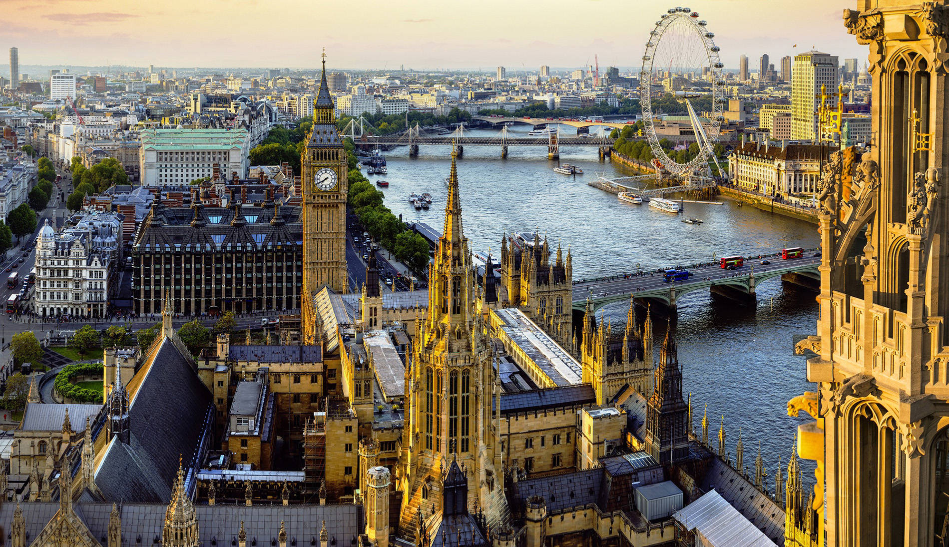 big ben 桌布 壁紙 — 黃金時段的陽光沐浴著倫敦的標誌性天際線，包括大笨鐘、倫敦眼以及泰晤士河上的橋樑和船隻。