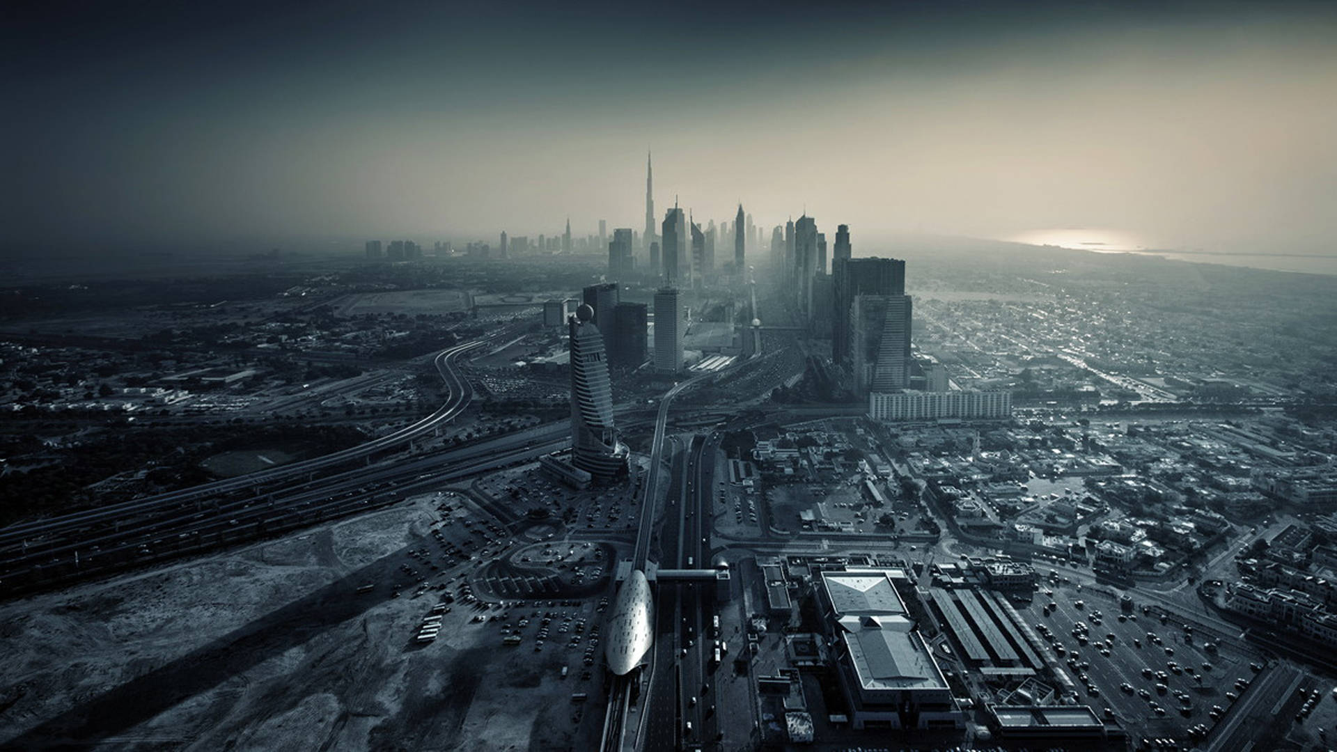 Arab 桌布 壁紙 — 黎明時分，廣闊未來城市景觀的鳥瞰圖，高聳的摩天大樓和蜿蜒的高速公路在朦朧的天空下。