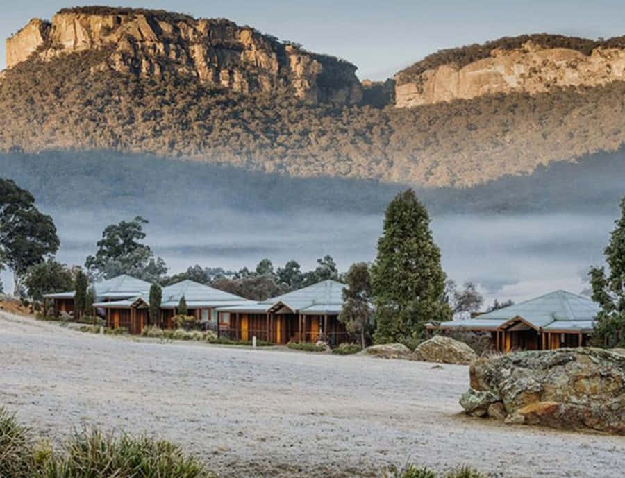 Blue Mountains National Park 桌布 壁紙 — 黎明時分，木屋坐落在霧氣瀰漫的山谷中，高聳的懸崖和結霜的地面。