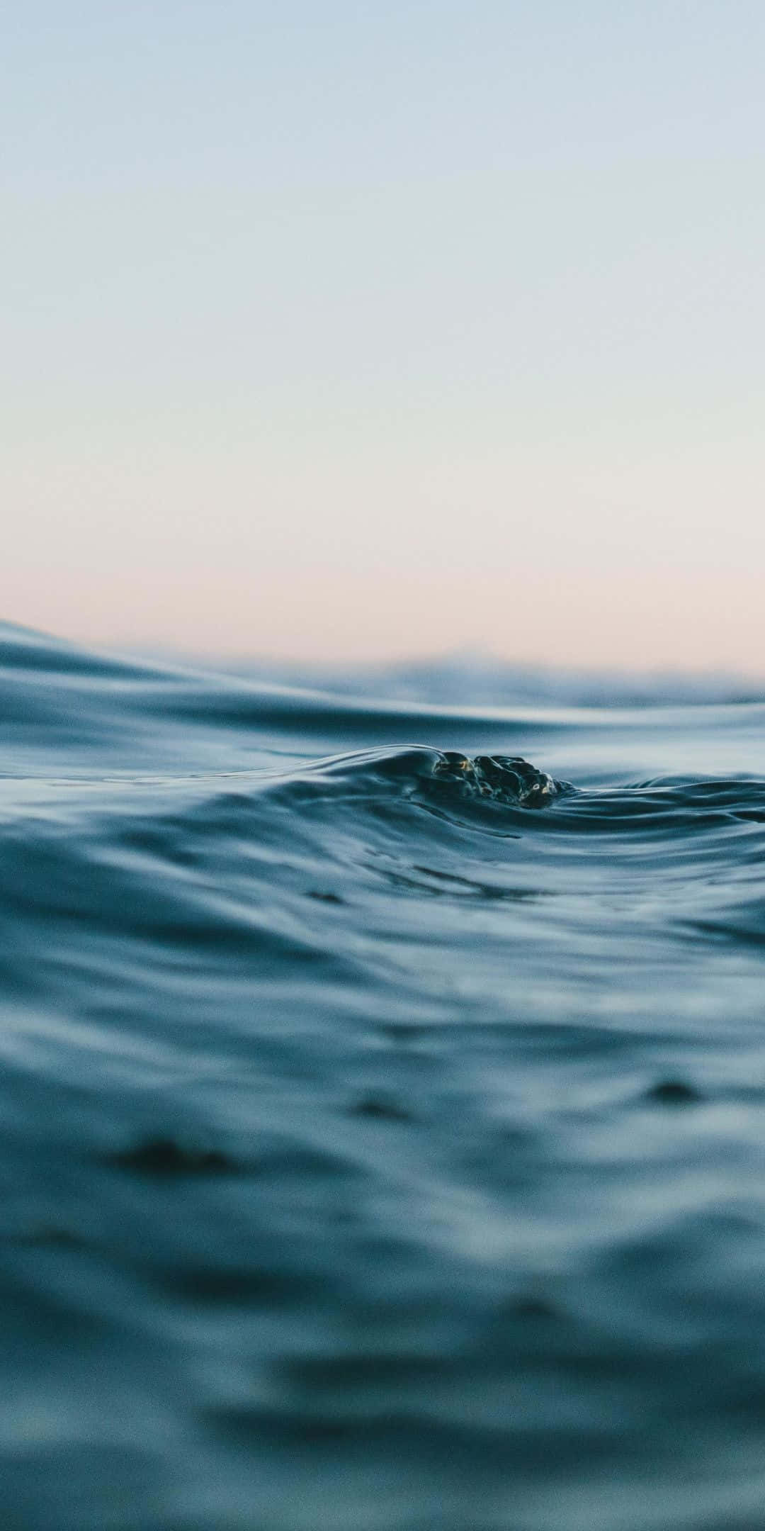 Ocean Aesthetic Phone 桌布 壁紙 — 黎明時分，柔和粉彩天空下，海浪輕輕翻湧的寧靜特寫。