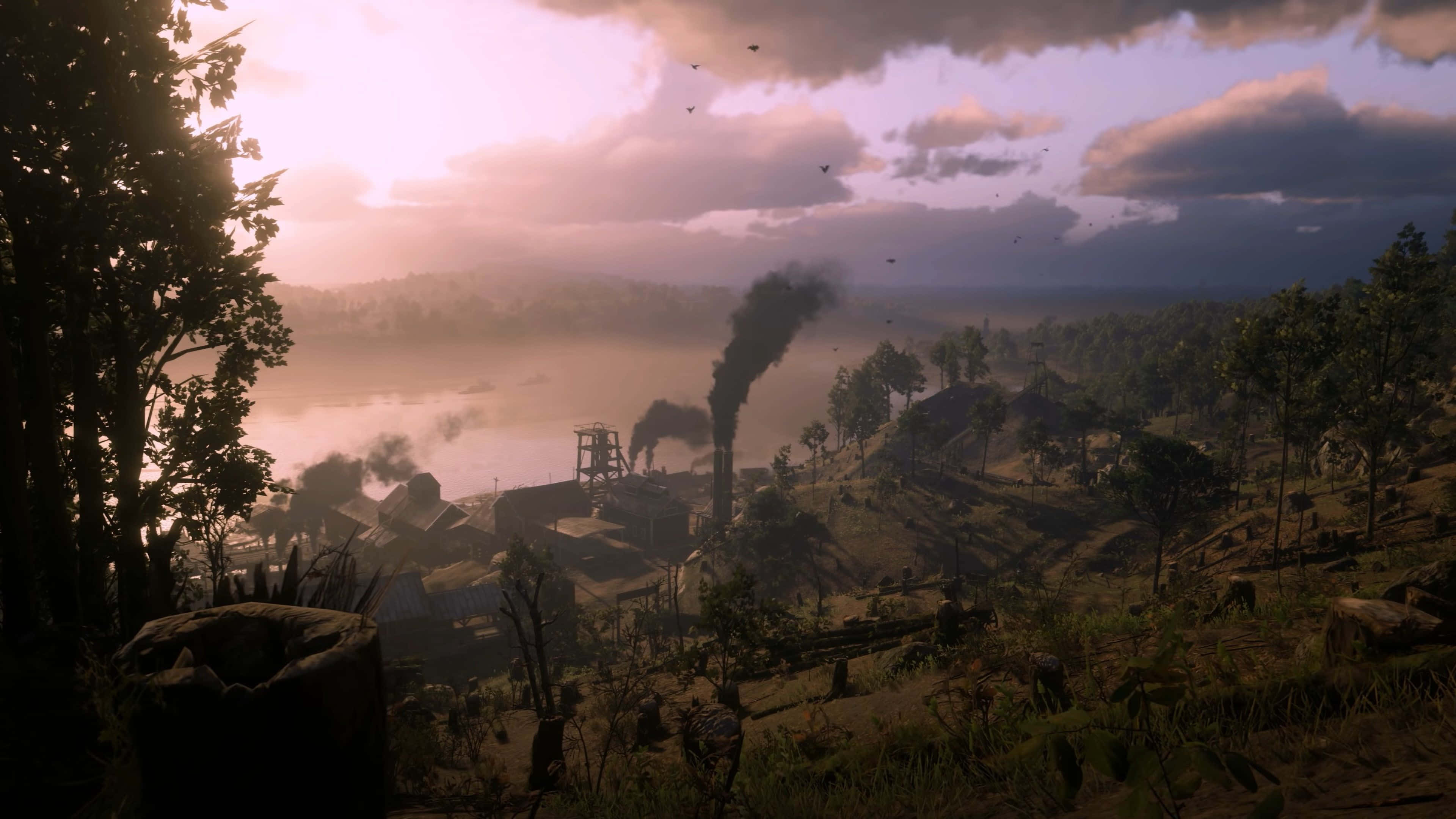 Red Dead Redemption 4K 桌布 壁紙 — 黎明時分，霧氣瀰漫的工業谷地，煙囪向河流和散落的樹木上方排放出黑色煙羽，天空呈現柔和的粉紫色。