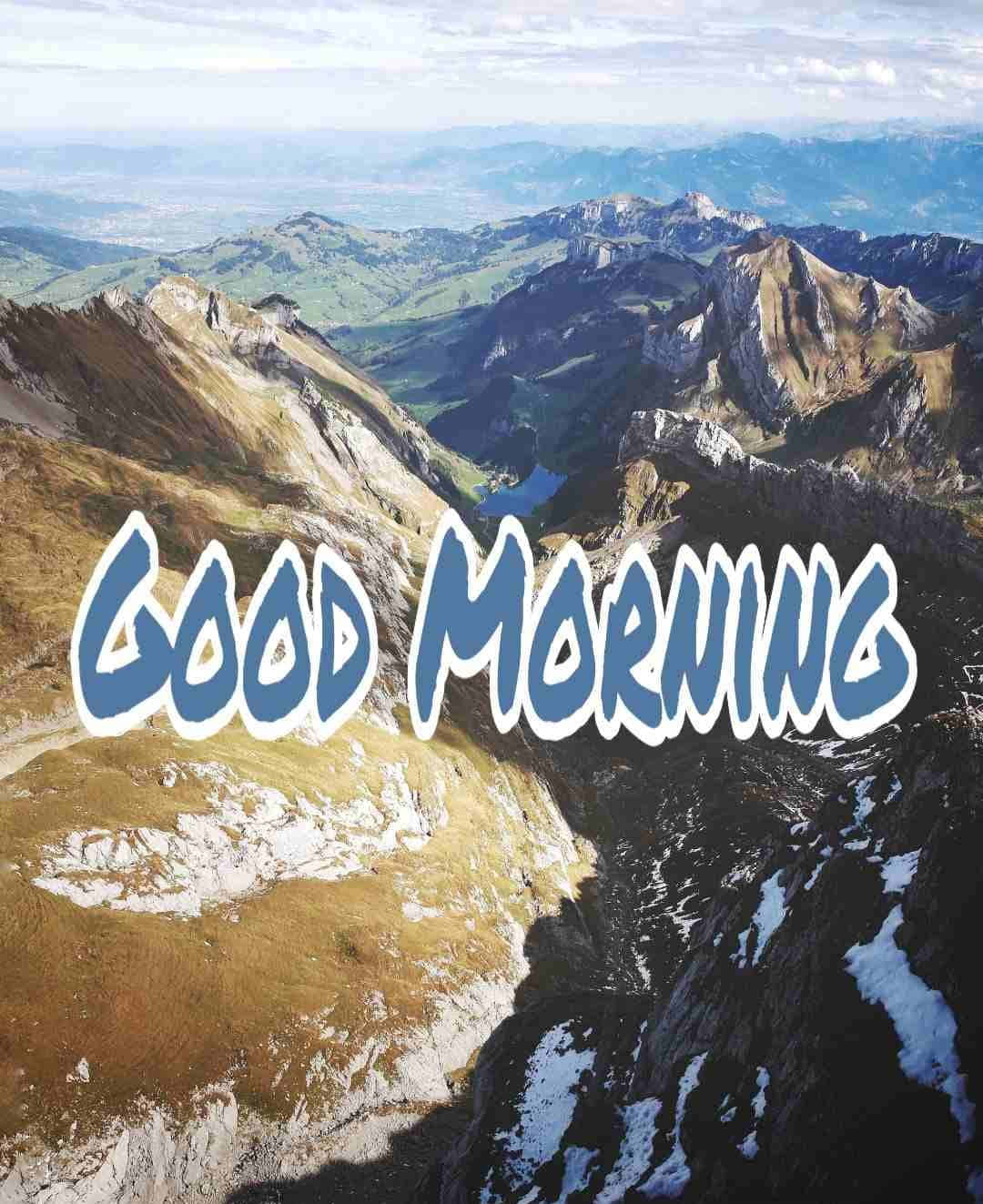 早安 桌布 壁紙 — 黎明時分令人驚嘆的山景，崎嶇的山峰和山谷上覆蓋著「早安」文字。