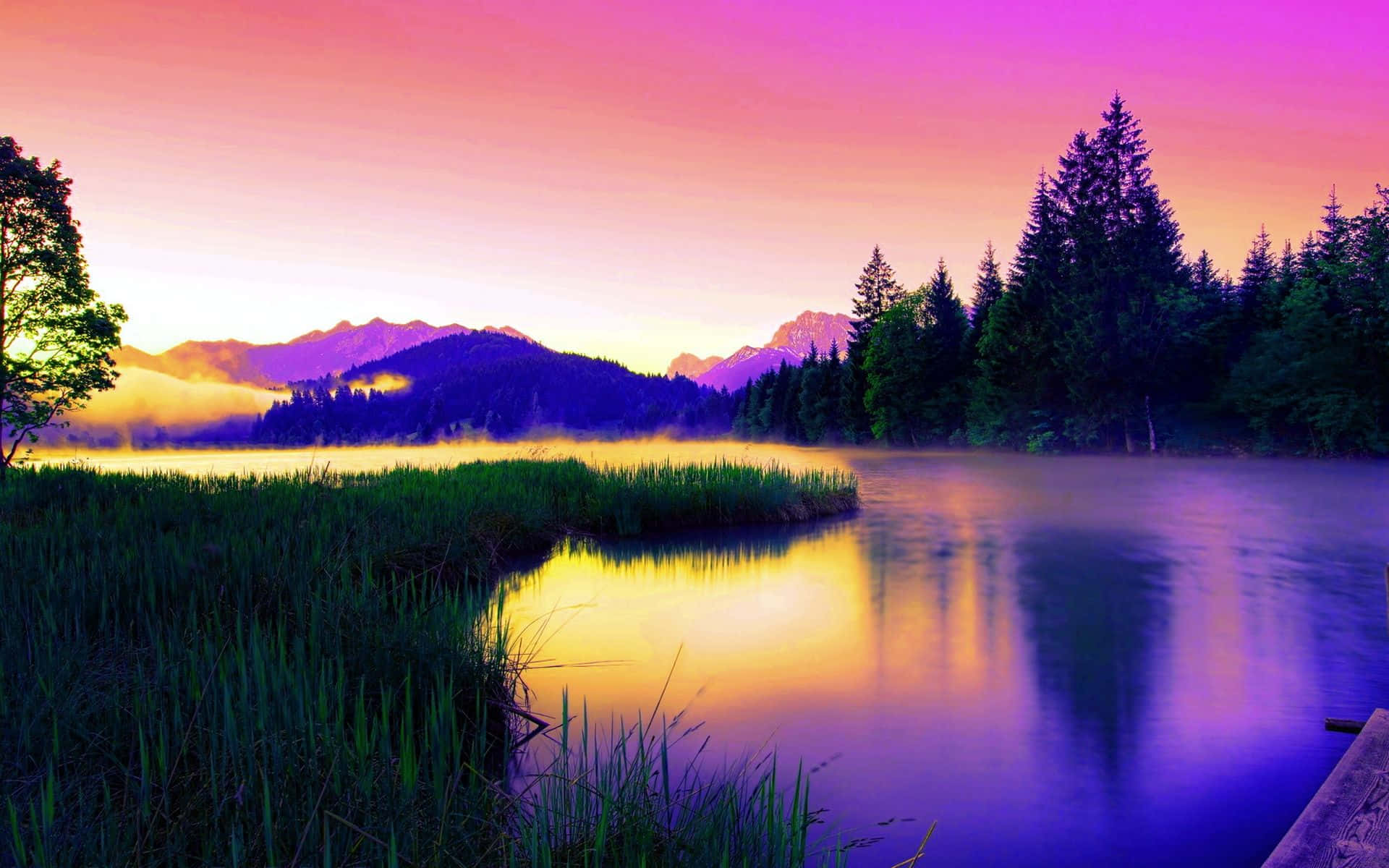 Beautiful Lake 桌布 壁紙 — 黎明時分的寧靜湖泊映照出充滿活力的粉紅色和紫色天空，薄霧從遠處的山脈和常青樹上升起。