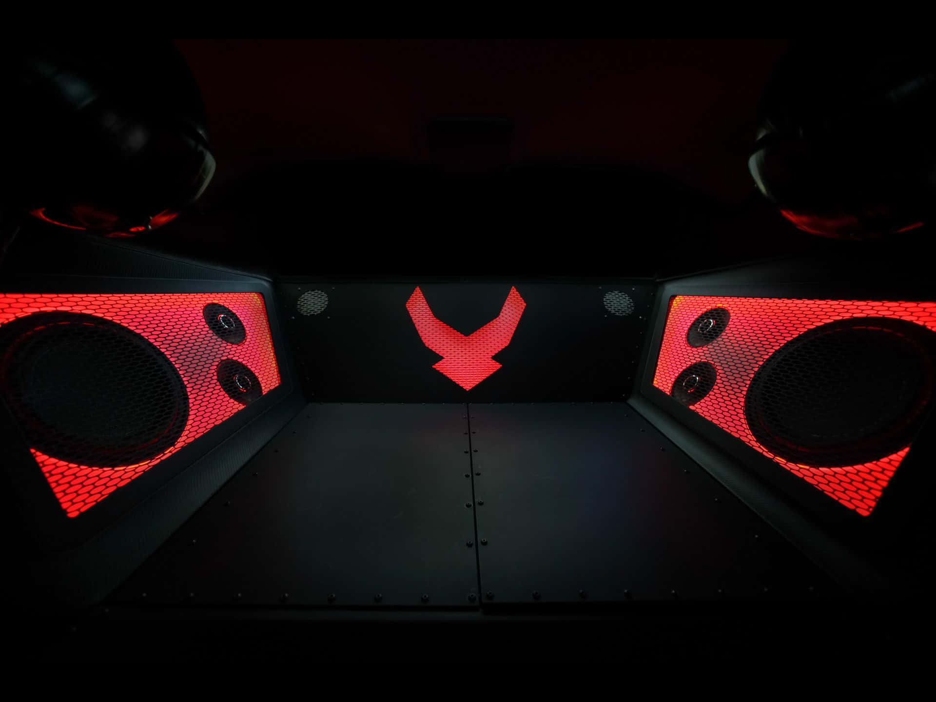 Car Audio 桌布 壁紙 — 黑暗內部，黑色面板上有發光的紅色揚聲器和紅色標誌。