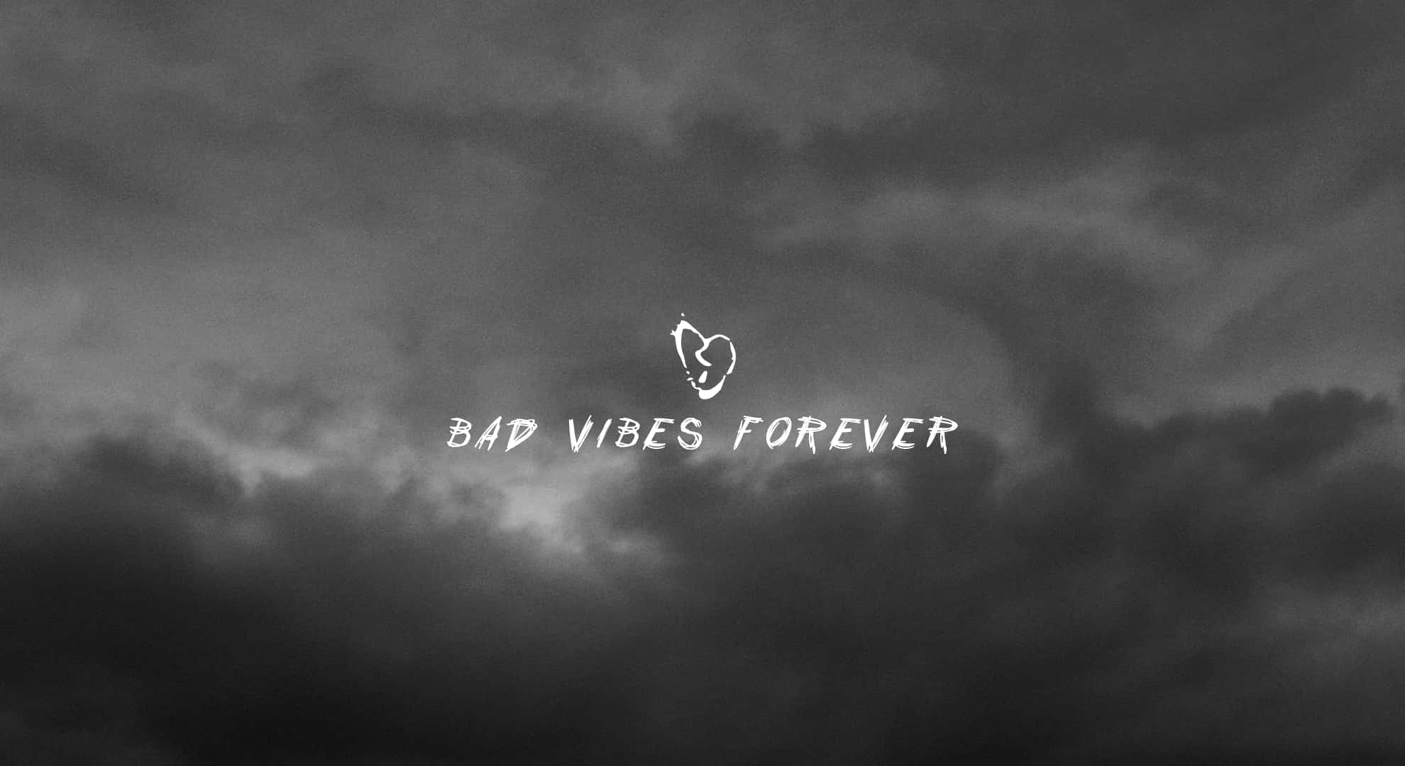 Bad Vibes 桌布 壁紙 — 黑暗的暴風雲佈滿天空，帶有粗體白色文字寫著 bad vibes forever 和一個心形符號。