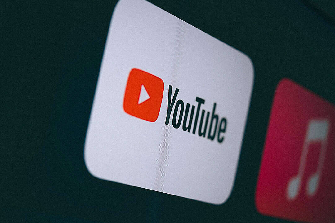 社群 桌布 壁紙 — 黑暗螢幕上發光的YouTube應用程式圖示特寫，旁邊有一個模糊的音樂應用程式圖示。