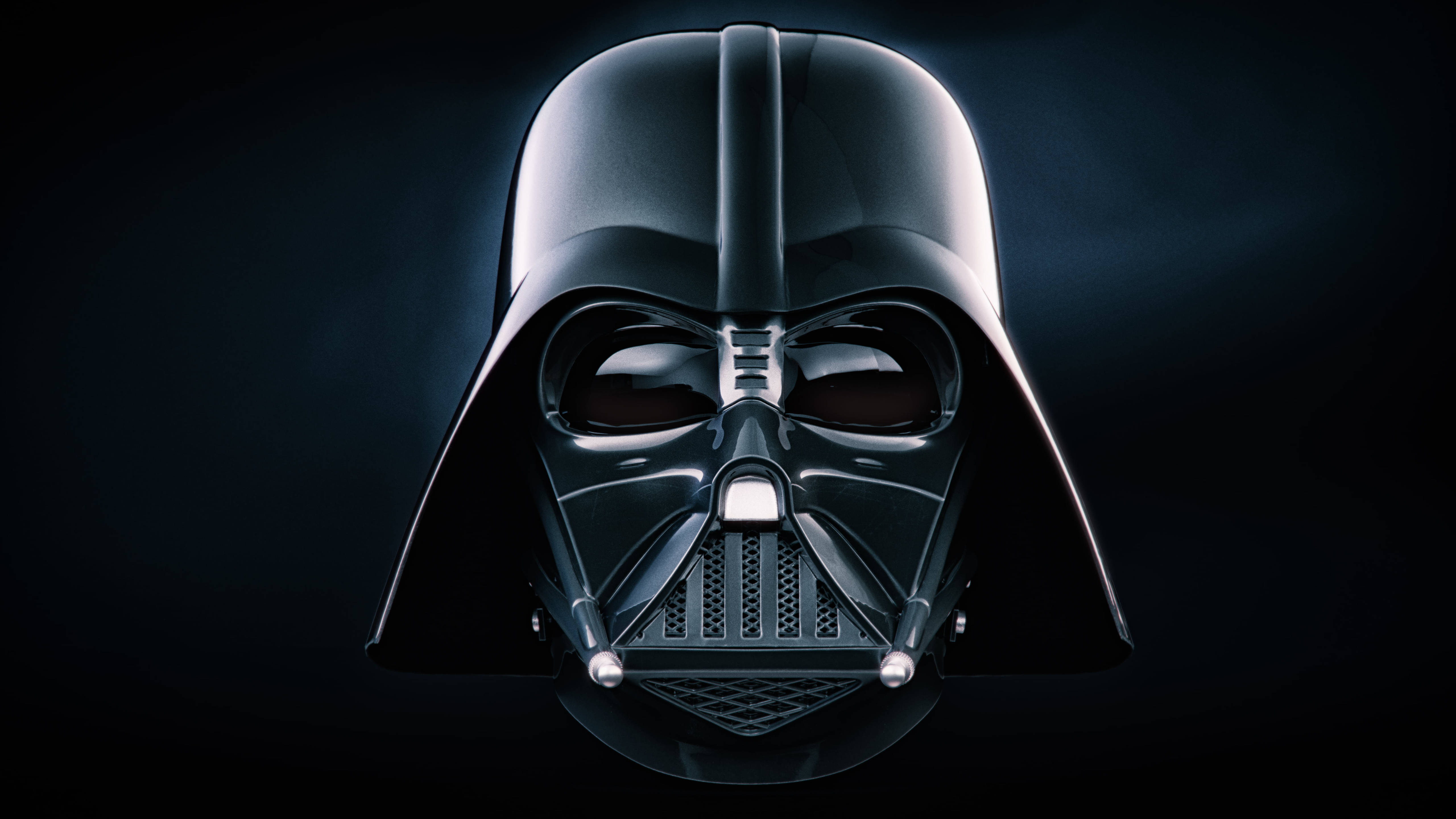 Vader 桌布 壁紙 — 黑武士標誌性黑色頭盔的特寫，紅色眼睛在黑暗背景中發光。