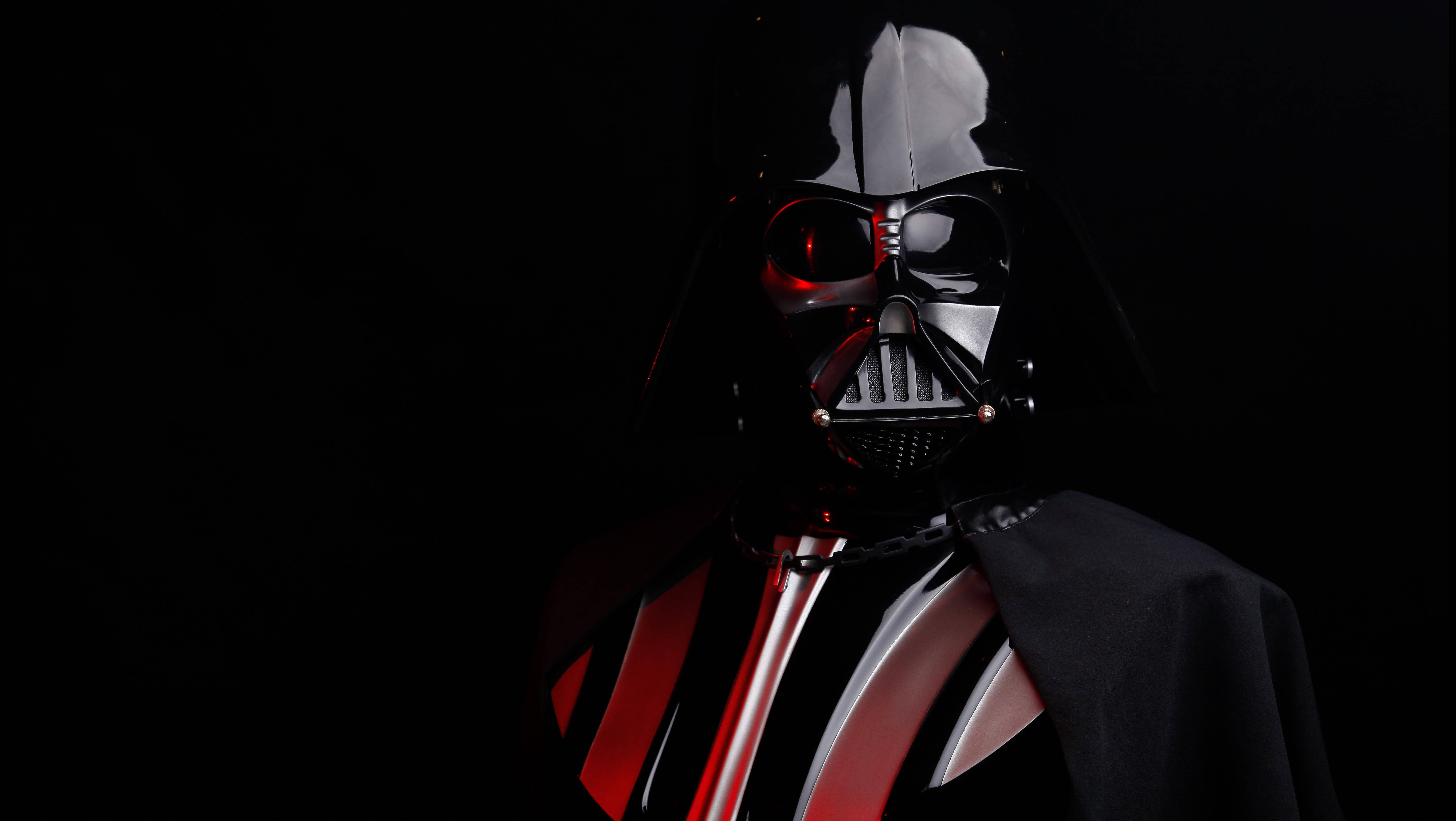 Vader 桌布 壁紙 — 黑武士的標誌性頭盔在漆黑背景中閃爍著紅光，突顯其威懾力。