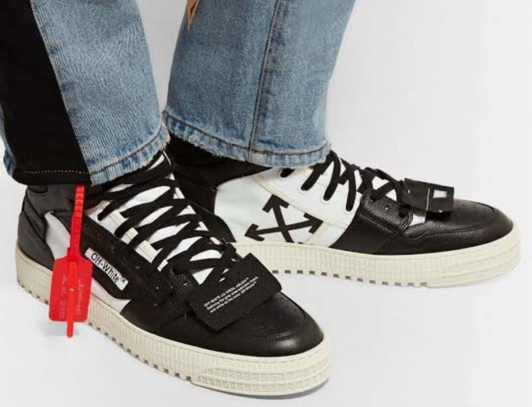 off white 桌布 壁紙 — 黑白Off-White運動鞋近距離特寫，帶紅色標籤和牛仔褲，背景為純白色。