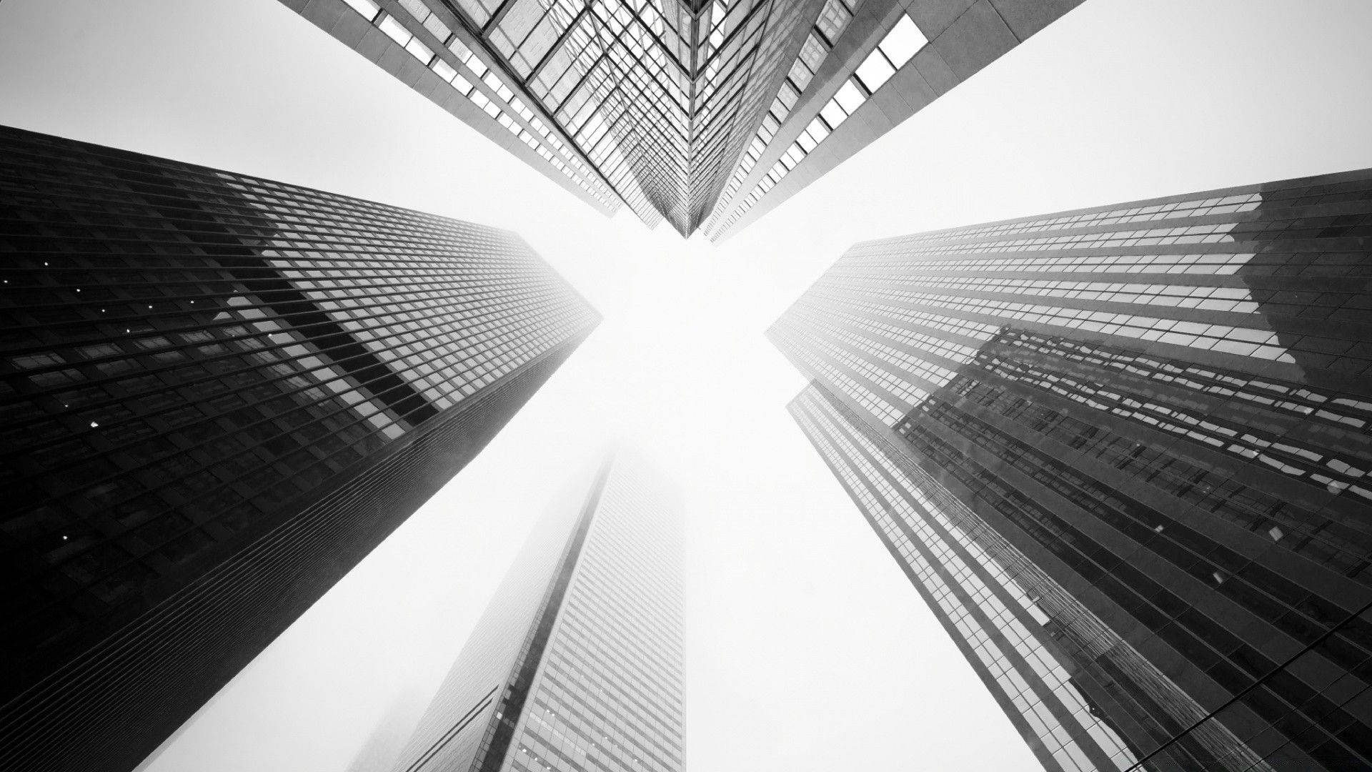 建築 桌布 壁紙 — 黑白低角度拍攝，高聳的摩天大樓向明亮的天空匯聚。