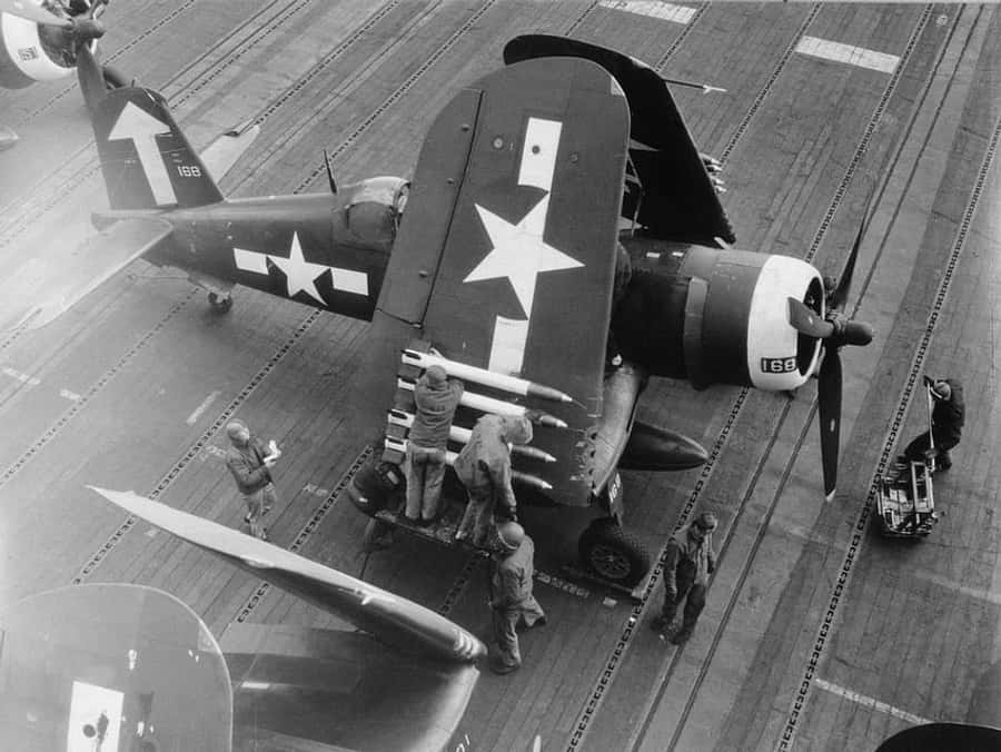 World War 2 桌布 壁紙 — 黑白俯視圖，水手在航空母艦甲板上維修二戰時期的戰鬥機。