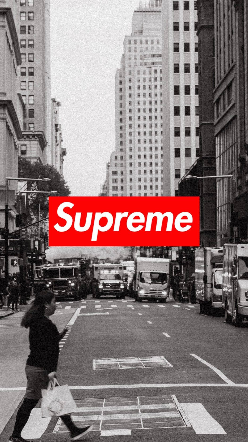 supreme aesthetic 桌布 壁紙 — 黑白城市街景，一名女子正在過馬路，中央疊加了一個粗體的紅色Supreme標誌。