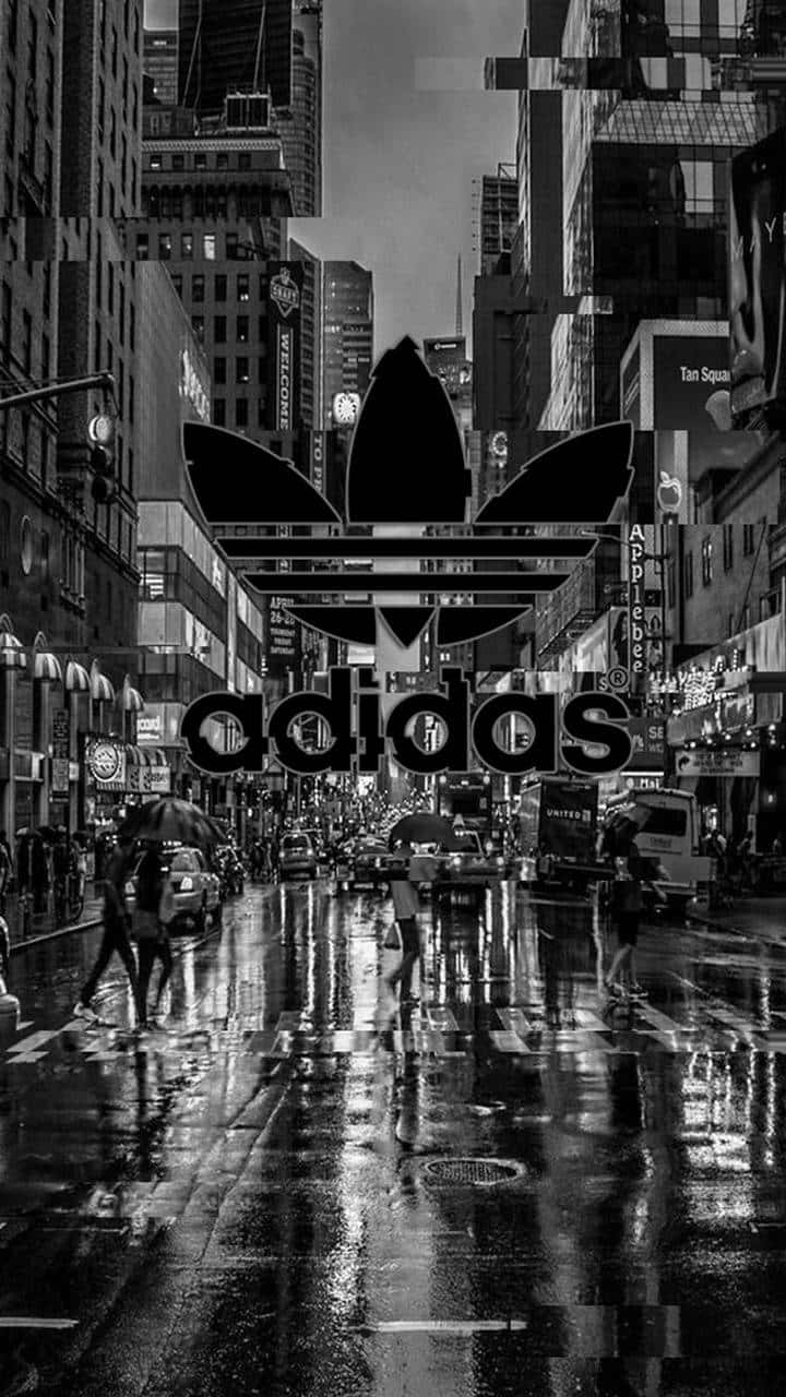 桌布 壁紙 — 黑白城市街景，巨型Adidas標誌疊加在雨中城市景觀上，有行人及倒影。