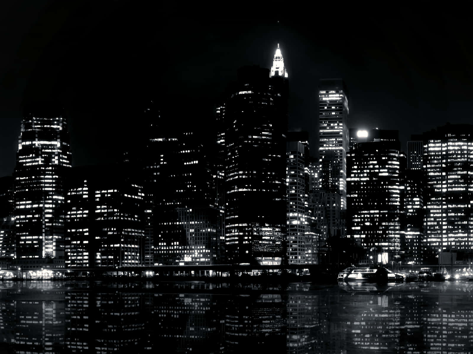 酷黑 桌布 壁紙 — 黑白夜景城市景觀，高聳的摩天大樓，發光的窗戶倒映在平靜的水面上。