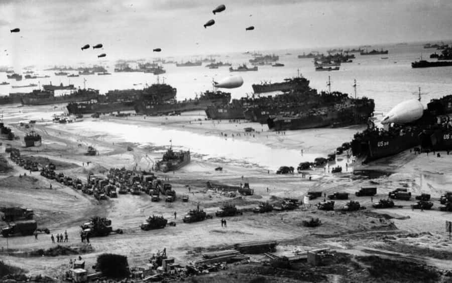 Battlefield 桌布 壁紙 — 黑白歷史照片，顯示大規模兩棲登陸，船隻、坦克和士兵在陰天下的海灘上