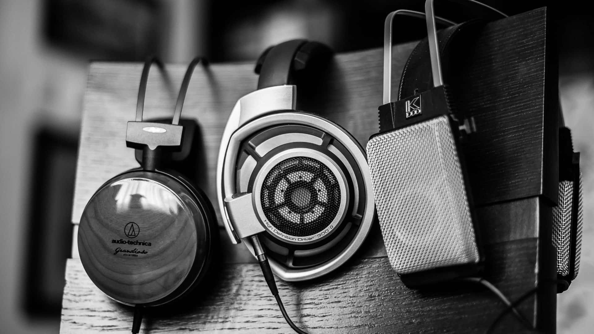 Black And White Music 桌布 壁紙 — 黑白照片，展示高端音響設備，包括耳機和麥克風，放置在木質表面上。