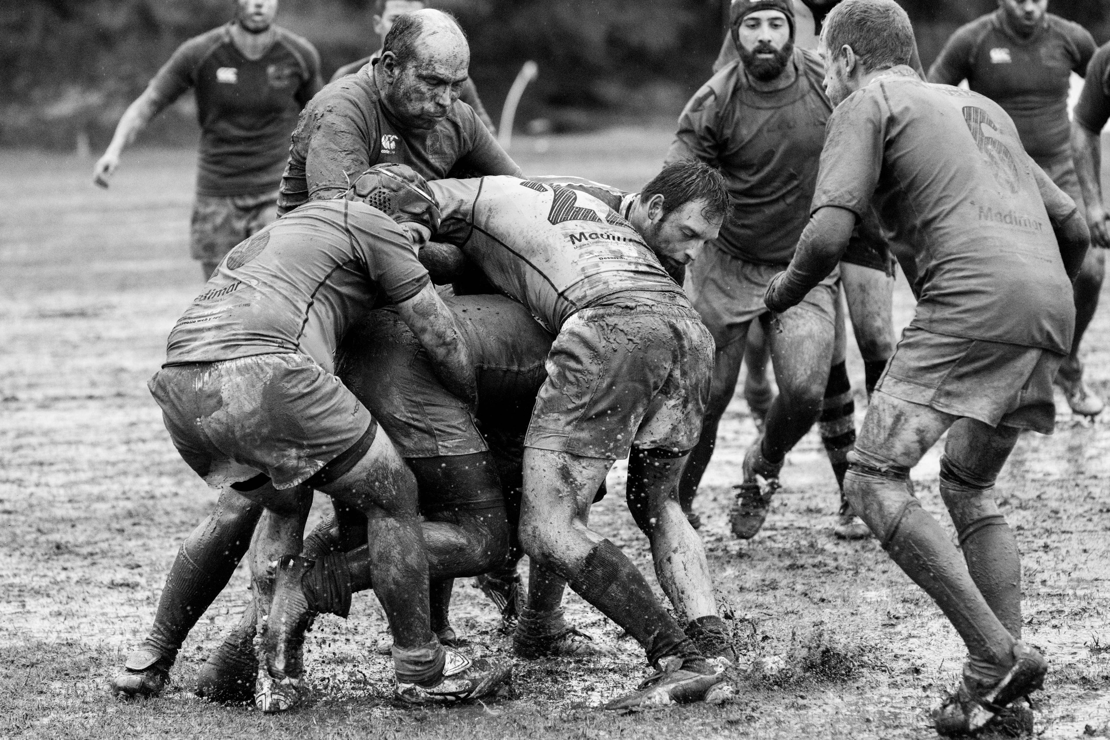Rugby 桌布 壁紙 — 黑白照片，草地上橄欖球球員在泥濘的爭球中糾纏。