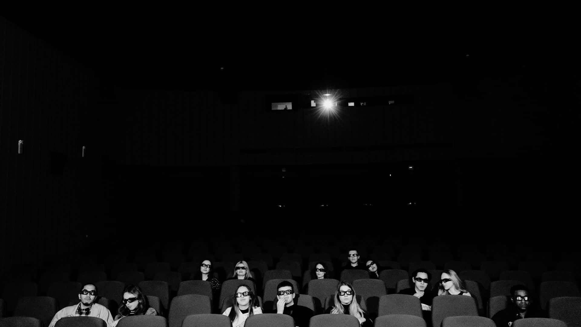 Black And White Movie 桌布 壁紙 — 黑白照片，觀眾在3D影院戴著眼鏡，頭頂單一燈光。