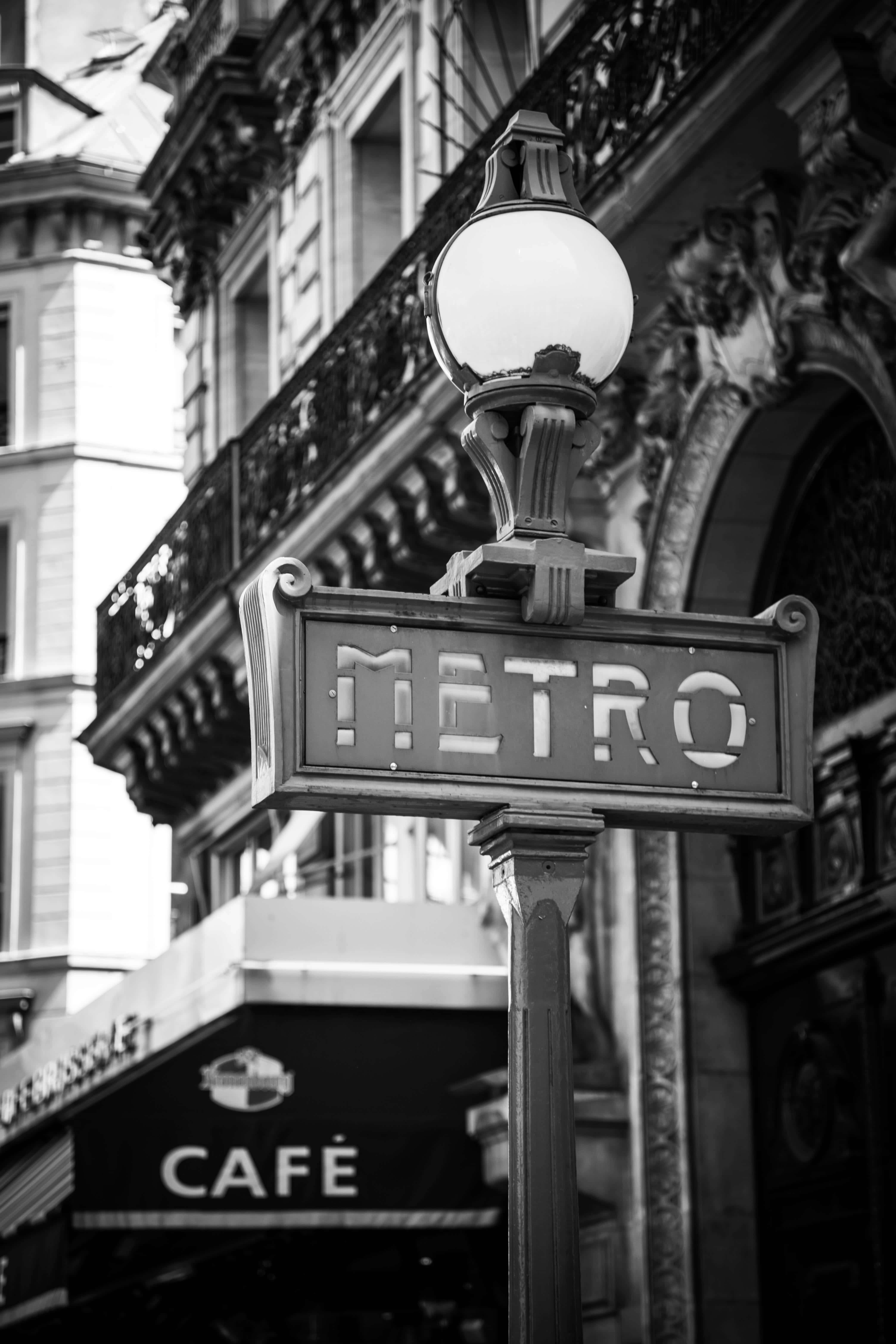 Black And White City 桌布 壁紙 — 黑白特寫，拍攝於一盞華麗街燈下、咖啡館遮陽篷旁的復古巴黎地鐵標誌。