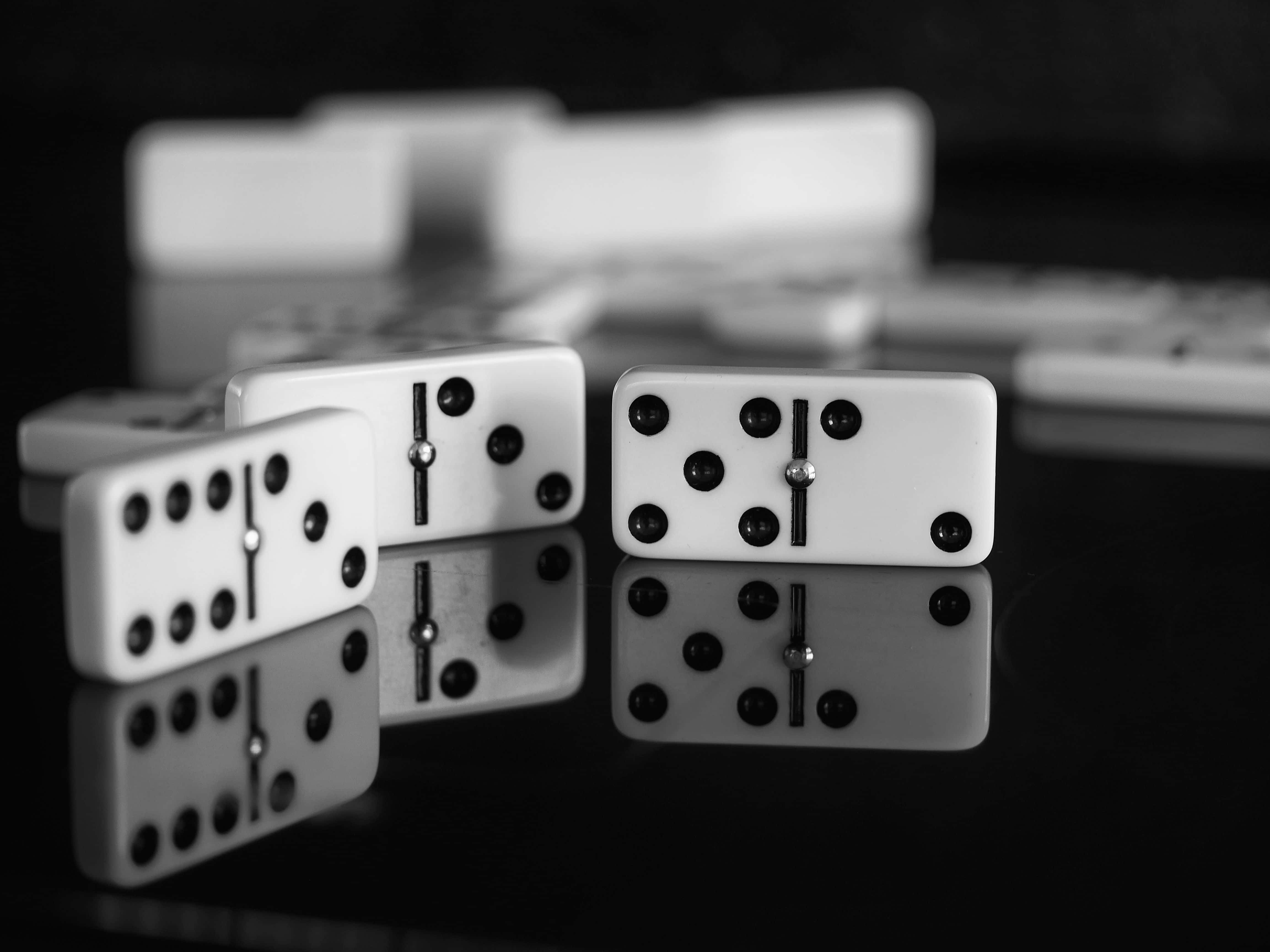 Domino 桌布 壁紙 — 黑白特寫，骨牌直立於反光表面，背景有模糊瓷磚。