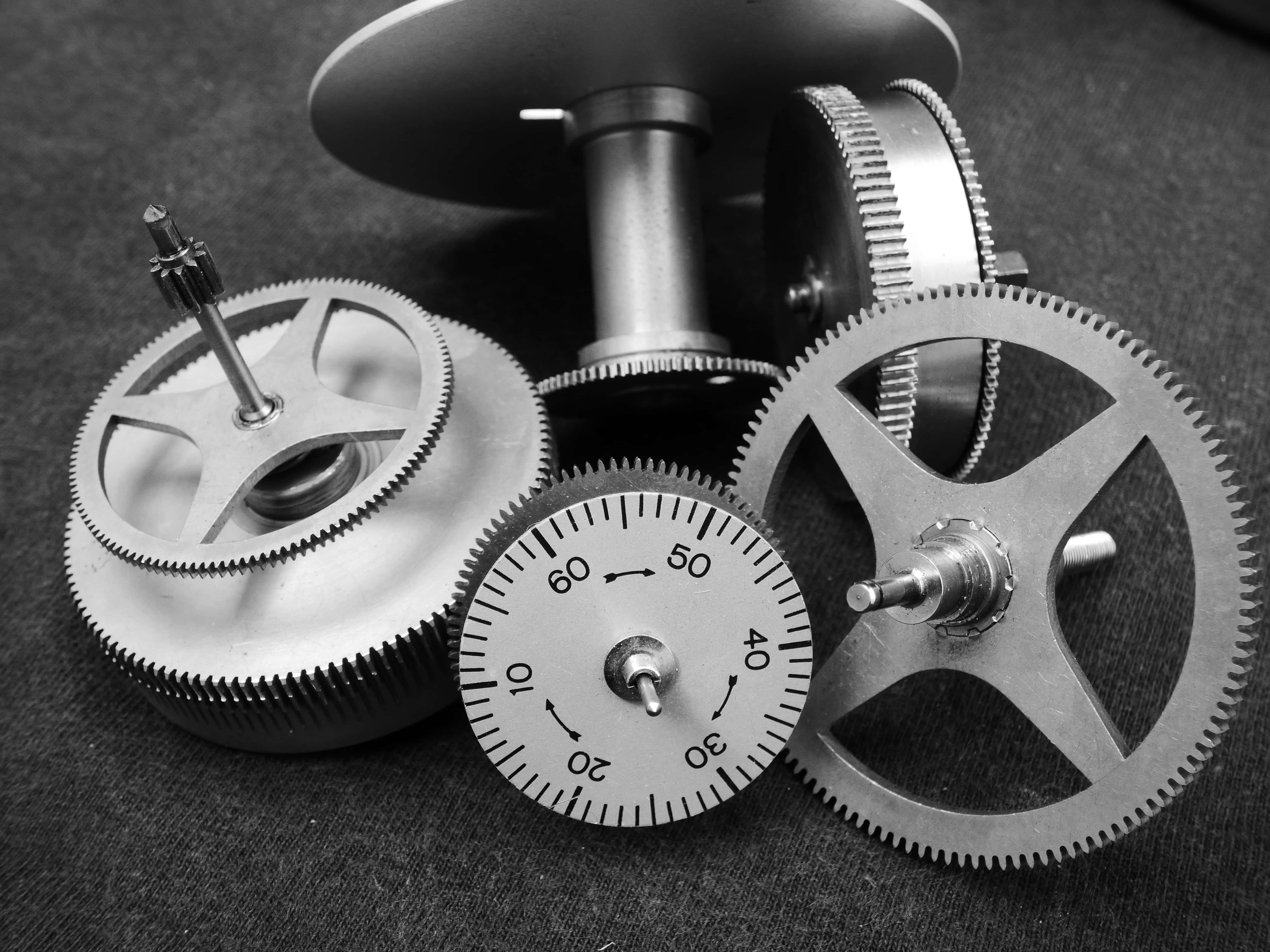 Mechanical Engineering 桌布 壁紙 — 黑白特寫金屬齒輪和計時器錶盤排列在紋理織物表面上。