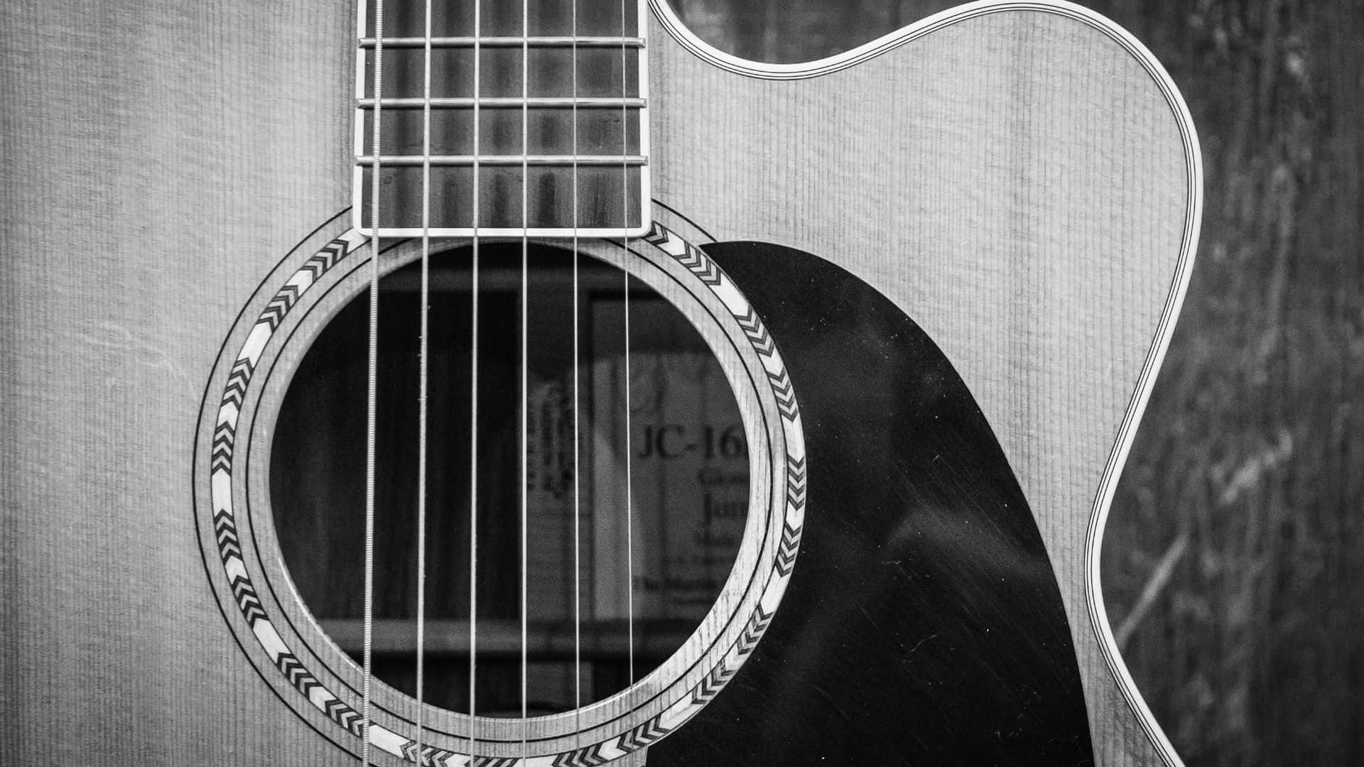Black And White Guitar 桌布 壁紙 — 黑白特寫鏡頭，展示原聲吉他的音孔和琴弦，帶有精緻的玫瑰飾邊細節。