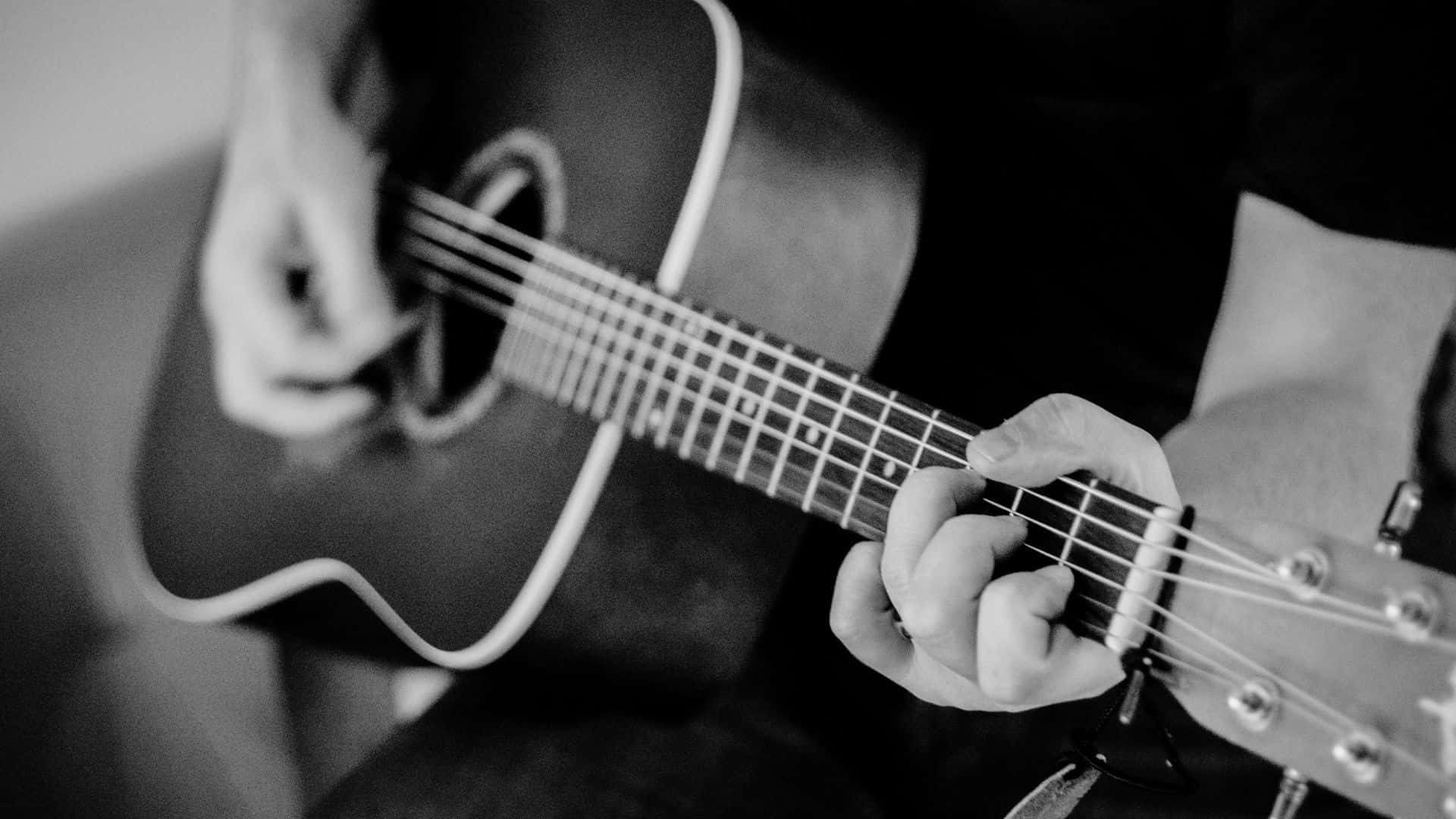 Black And White Guitar 桌布 壁紙 — 黑白特寫鏡頭，雙手熟練地彈奏原聲吉他，聚焦於指板和琴弦。