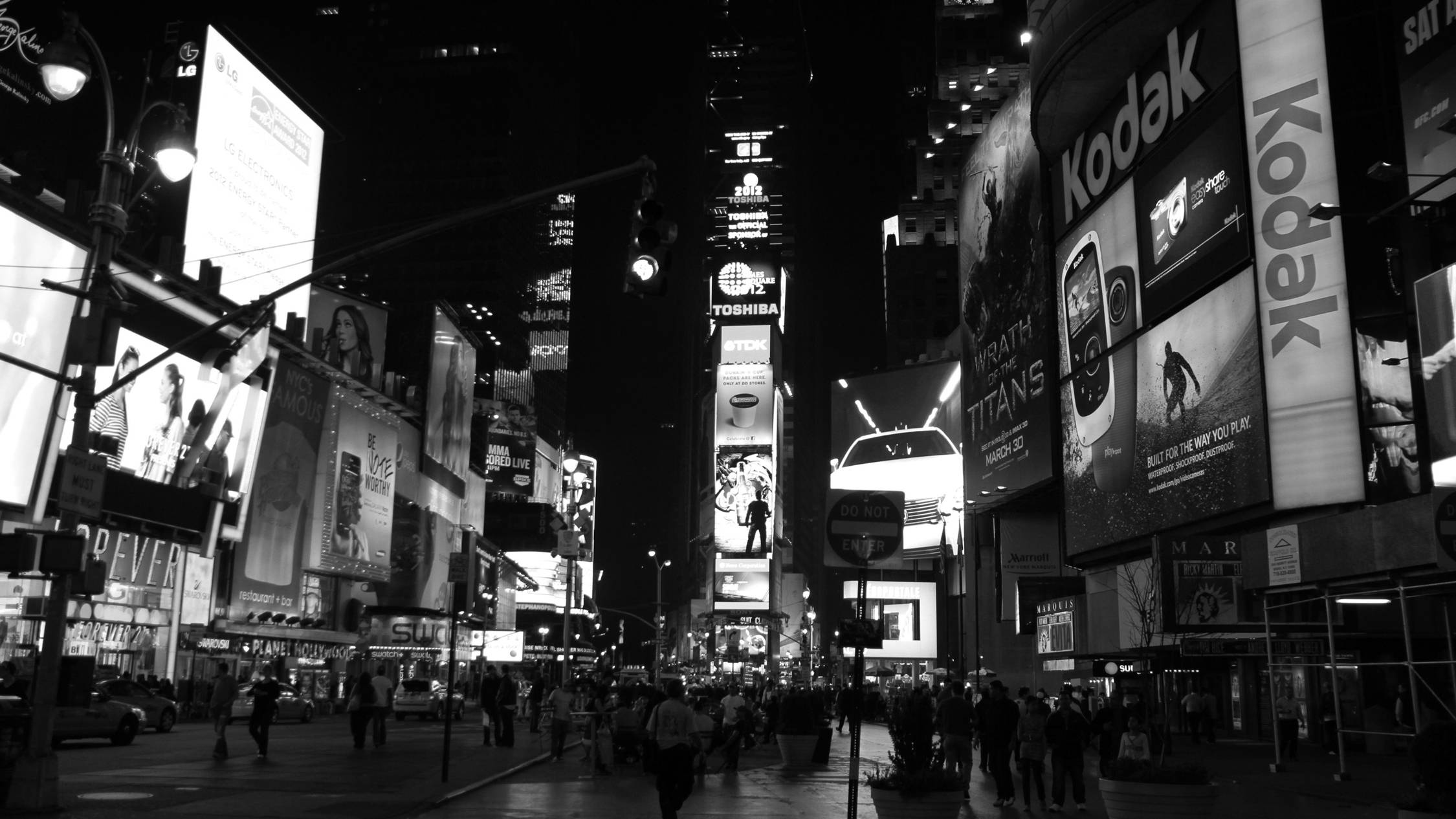 New York 桌布 壁紙 — 黑白相間、熙來攘往的夜景城市景觀，聳立的廣告牌和成群的行人。