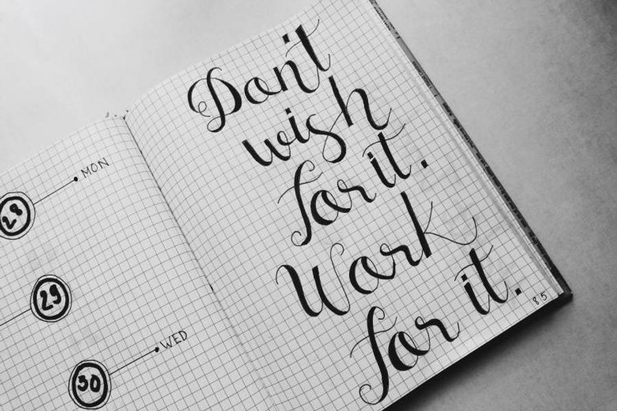 Motivation 桌布 壁紙 — 黑白筆記本頁面上，粗體書法寫著「不要只希望，要為之努力。」在方格紙上。
