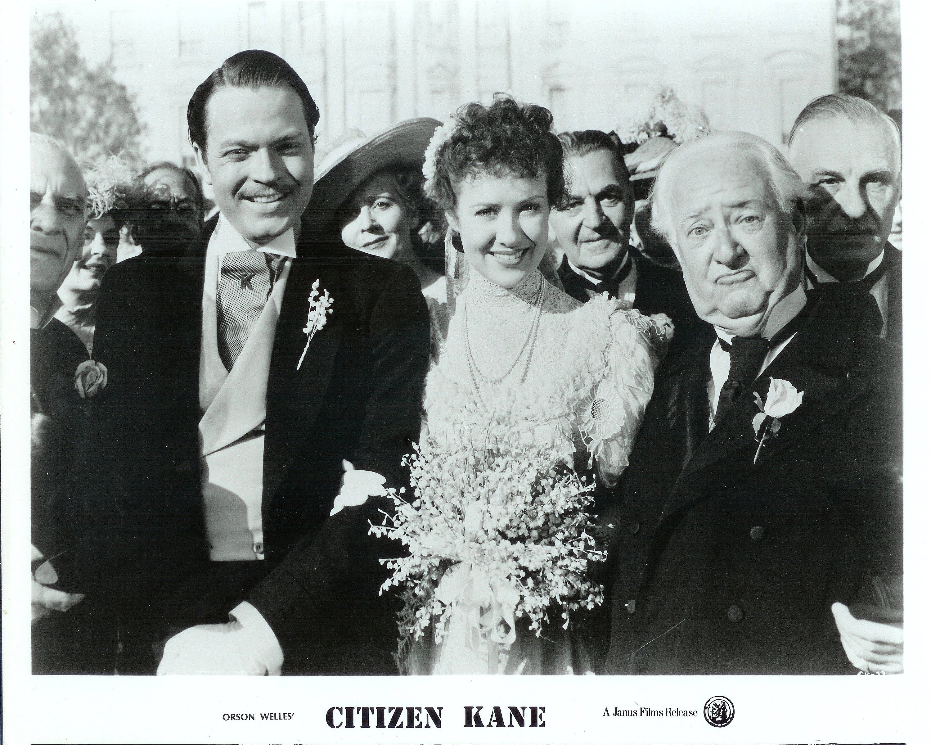 Citizen Kane 桌布 壁紙 — 黑白電影劇照，一對微笑的新郎新娘被婚禮上穿著正式服裝的賓客包圍。