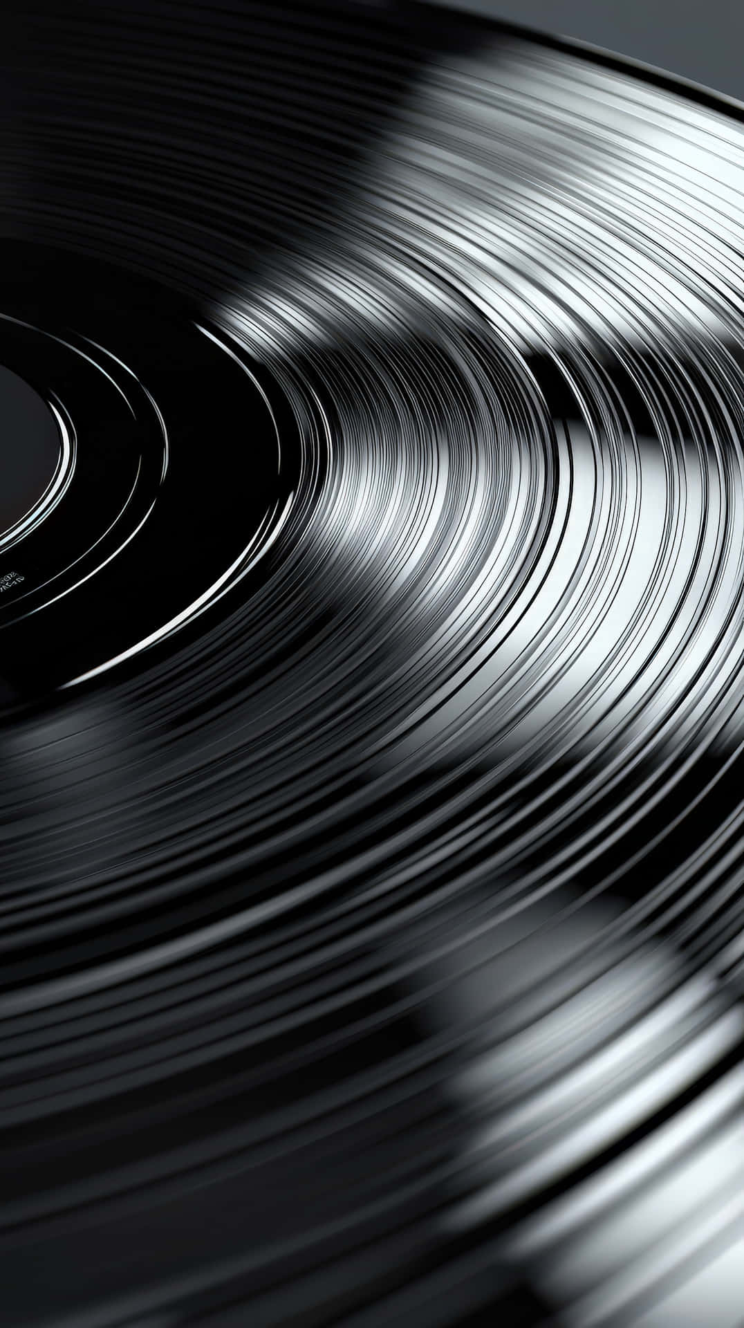 Close-up of a black vinyl record with grooves 壁紙 — 黑膠唱片溝槽的特寫，捕捉光線，形成強烈對比和深邃陰影。
