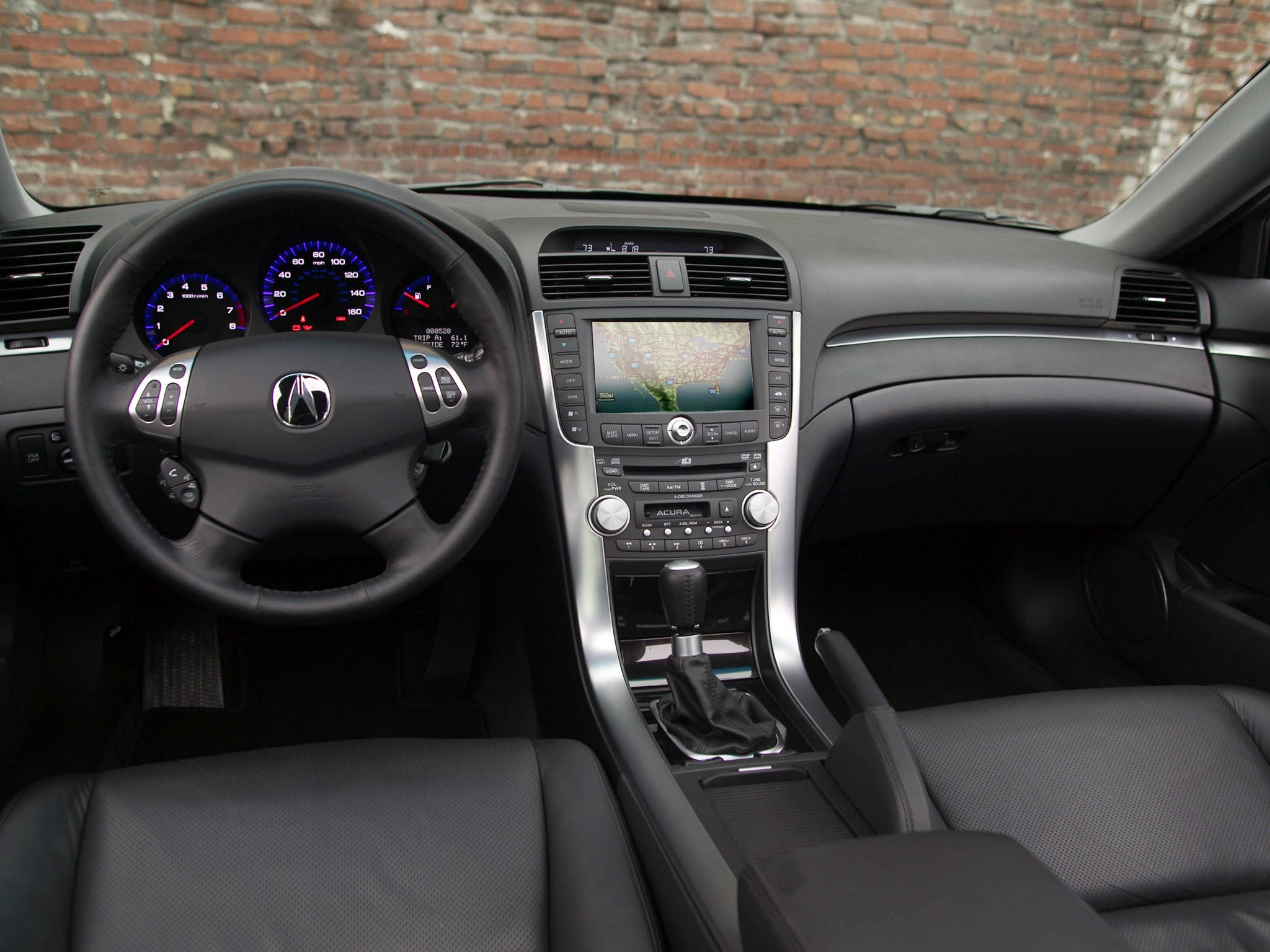 Acura 桌布 壁紙 — 黑色Acura汽車內部，帶有發光藍色儀表和導航螢幕，背景為磚牆。