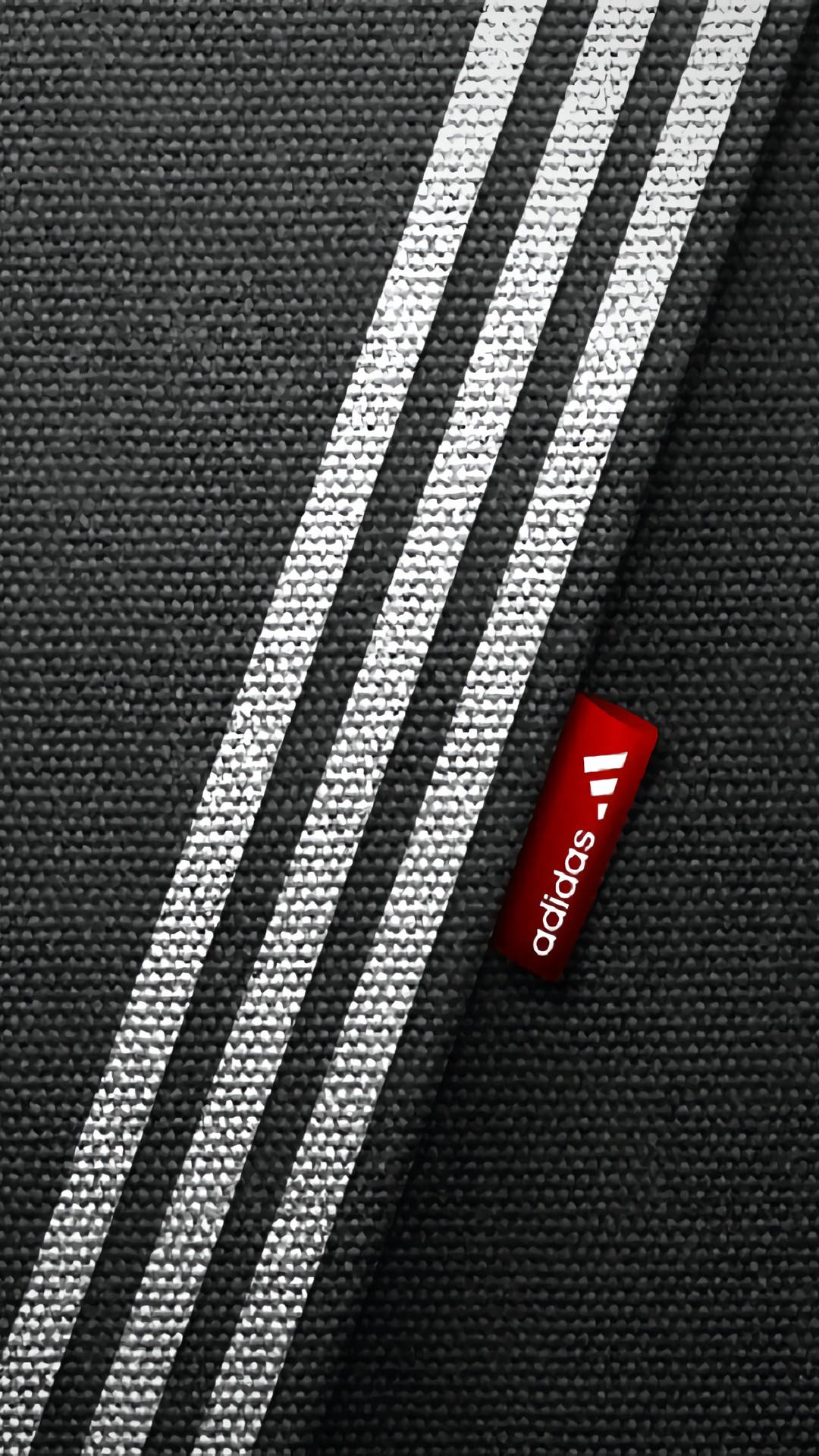 Samsung Galaxy S4 桌布 壁紙 — 黑色Adidas布料特寫，帶有三條白色條紋和一個紅色品牌標籤，顯示織物質感細節。